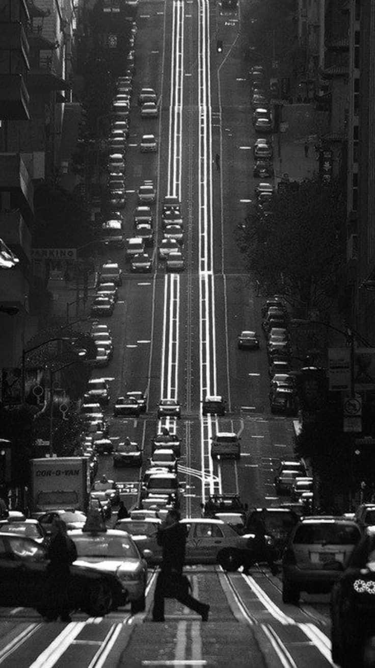 Black And White Street 桌布 壁紙 — 一張高角度黑白照片，拍攝繁忙的城市街道，滿是汽車和行人過馬路。
