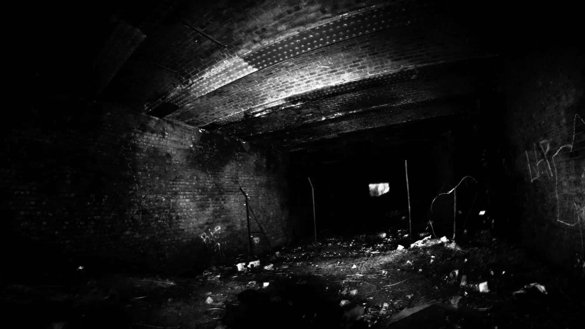Black And White Graffiti 桌布 壁紙 — 一張鮮明的黑白照片，展示了一個破舊的磚砌隧道，在昏暗光線下有碎片和塗鴉。