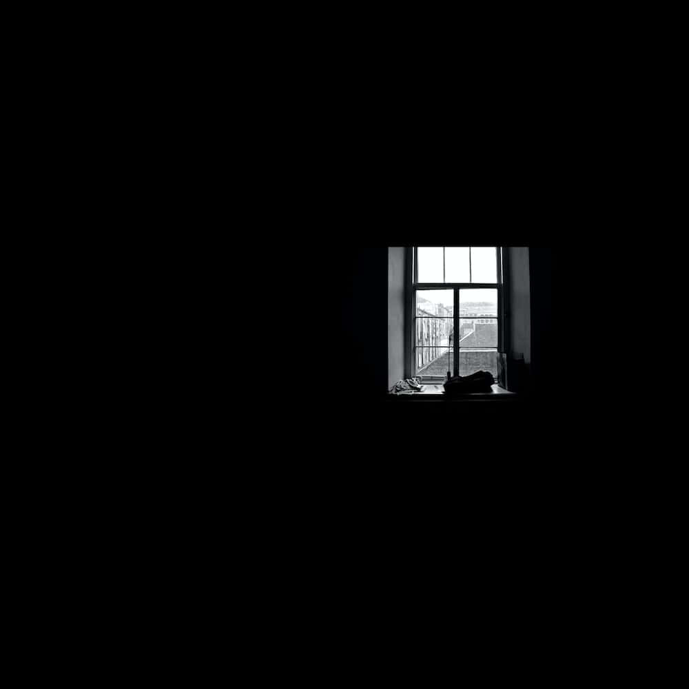 Window Shadow 桌布 壁紙 — 一張鮮明的黑白照片，顯示一個被黑暗框住的窗戶，露出遠處的城市景觀。