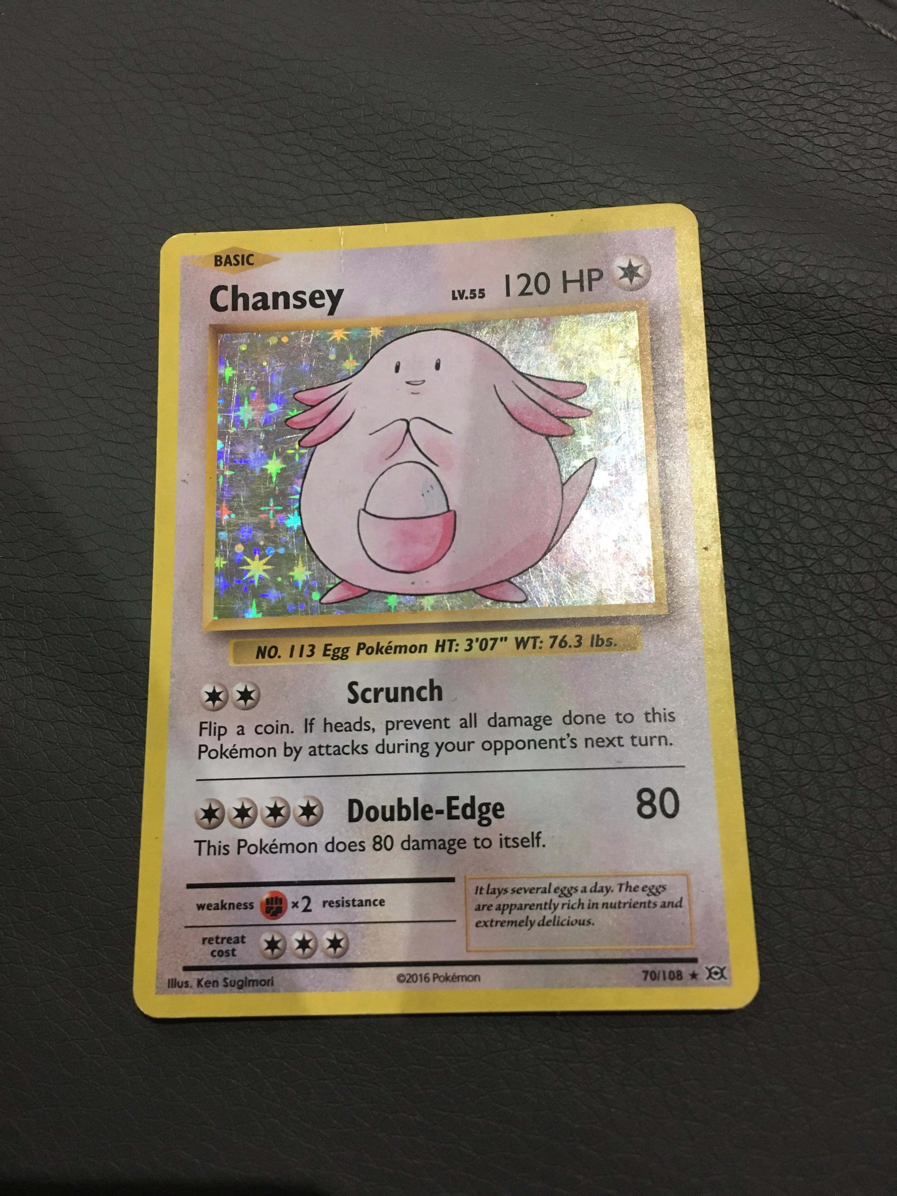 Pokemon Card 桌布 壁紙 — 一張黃色的寶可夢卡，上面有吉利蛋和全息星空背景，放在深色紋理表面上。