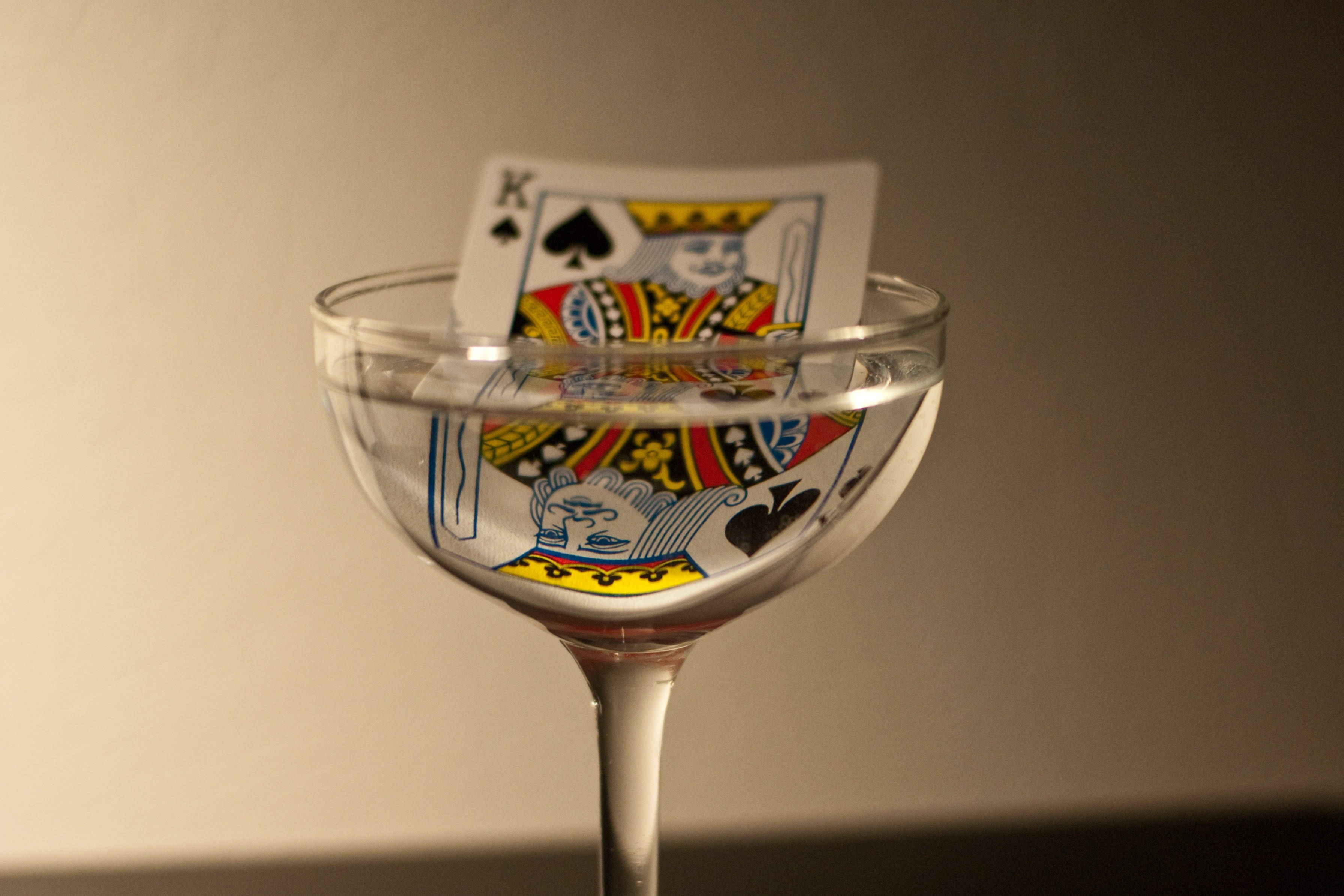 Playing Cards 桌布 壁紙 — 一張黑桃K撲克牌部分浸沒在裝滿水的透明雞尾酒杯中。