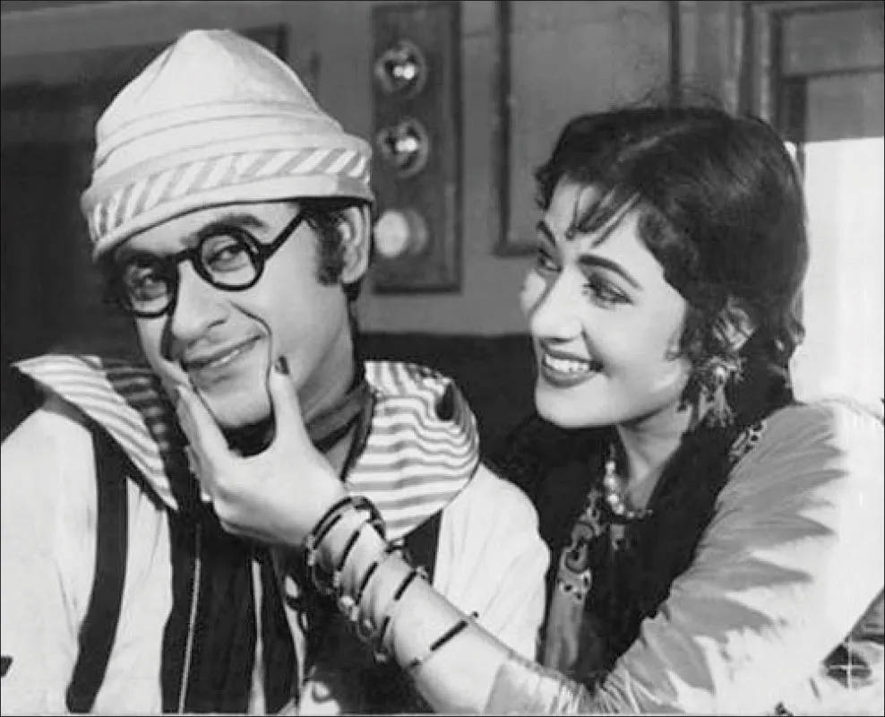 Kishore Kumar 桌布 壁紙 — 一張黑白復古電影劇照顯示，一名戴著條紋帽子和眼鏡的微笑男子，被一名戴著手鐲的微笑女子輕輕觸碰臉頰。