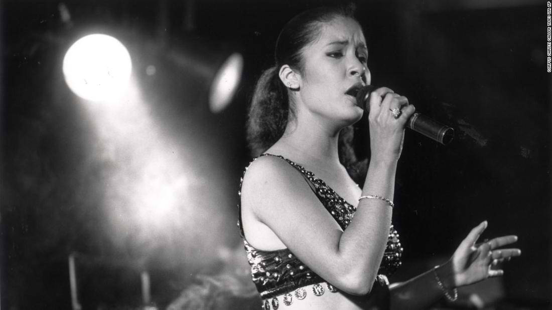 Selena Quintanilla 桌布 壁紙 — 一張黑白照片，一位女歌手在明亮的聚光燈下在舞台上表演，表情豐富。
