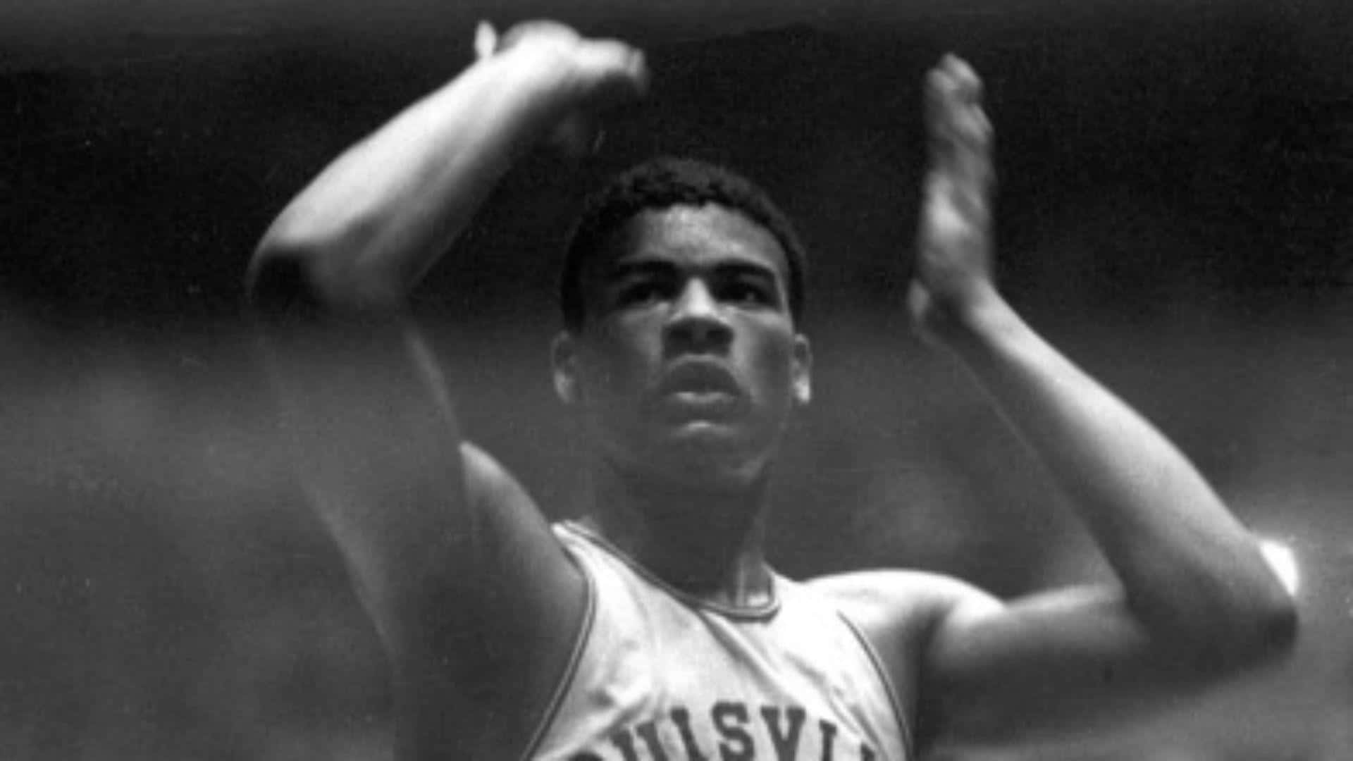 運動 桌布 壁紙 — 一張黑白照片，一名身穿Bulls Ville球衣的年輕男性運動員高舉雙臂，展現勝利或慶祝的姿態。