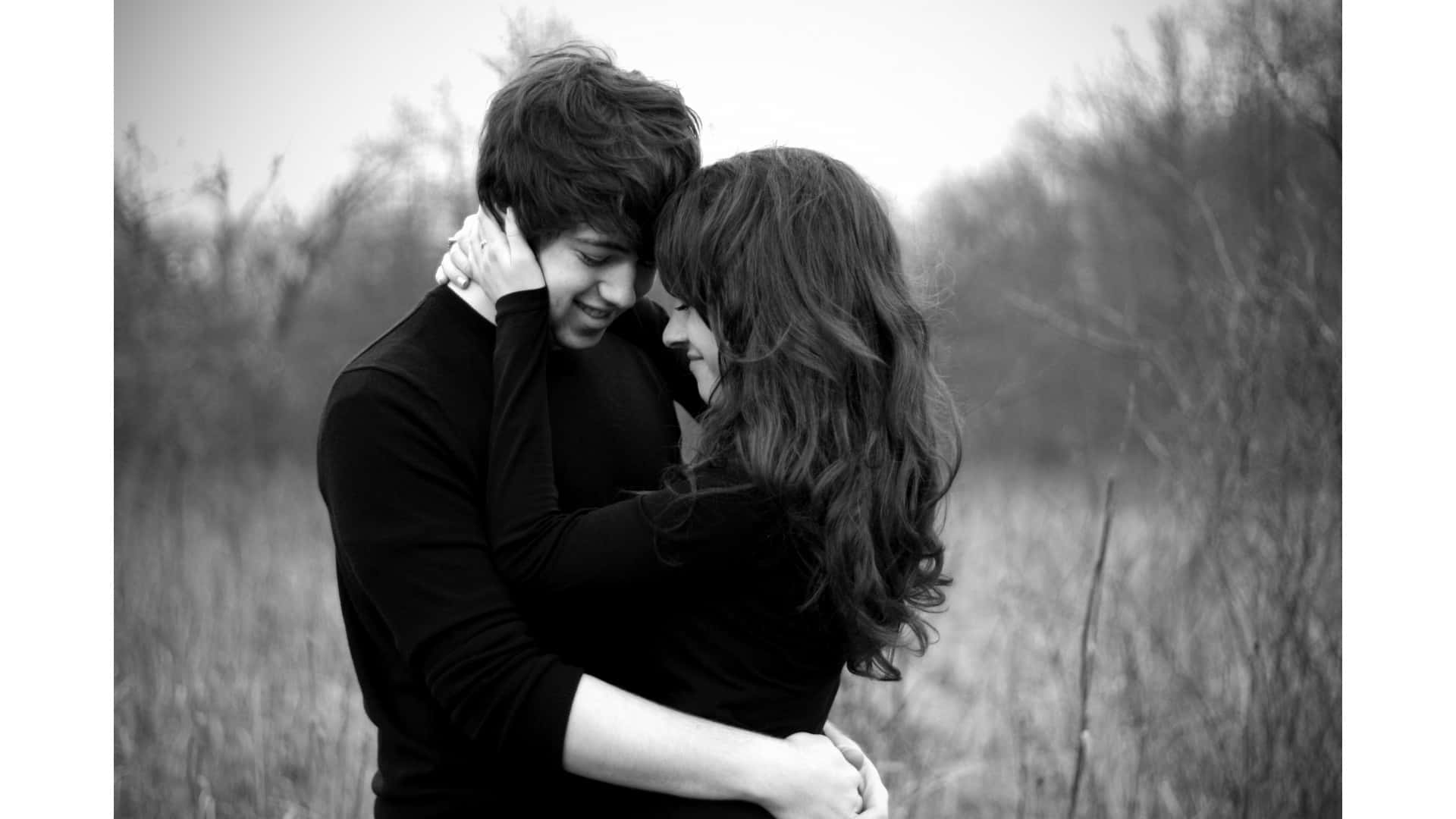Relationship 桌布 壁紙 — 一張黑白照片，一對微笑的情侶在草地上溫柔擁抱，背後有光禿的樹木。