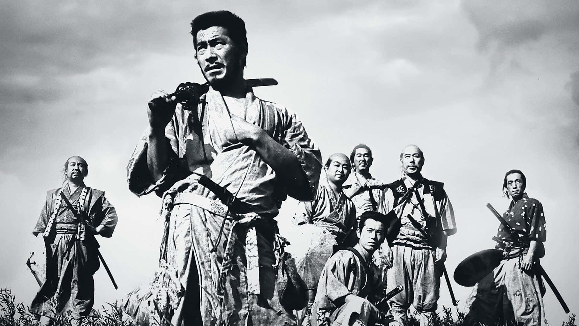 Samurai Movies 桌布 壁紙 — 一張黑白照片，七位身穿傳統長袍的武士站在山頂上，背景是陰雲密布的天空。