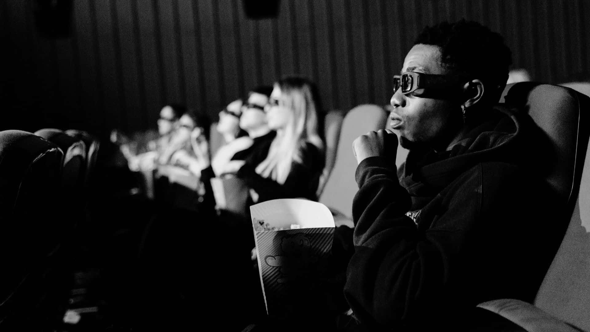 Black And White Movie 桌布 壁紙 — 一張黑白照片，人們在電影院戴著3D眼鏡吃爆米花。