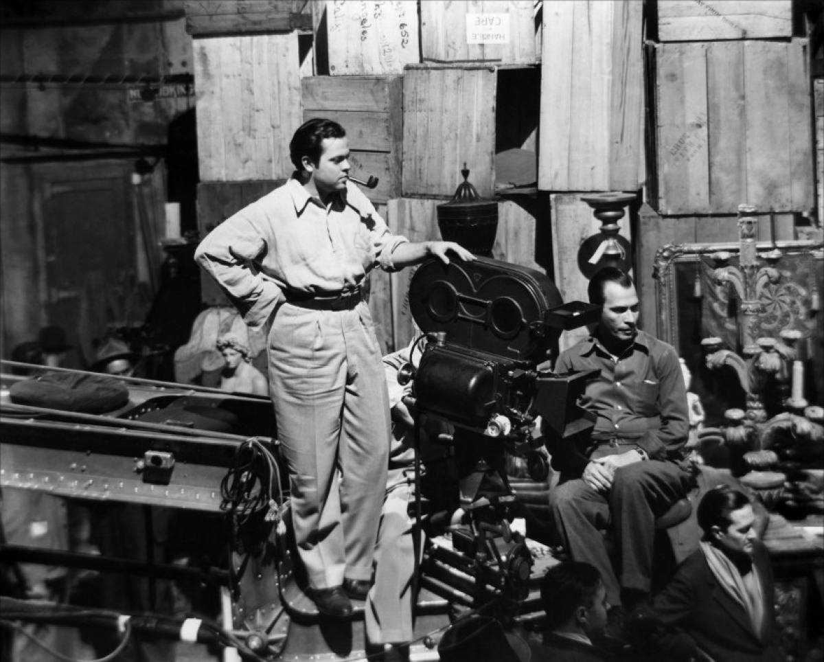 Citizen Kane 桌布 壁紙 — 一張黑白照片，展示一個復古電影場景，導演站在大型電影攝影機旁，周圍是工作人員和木箱。