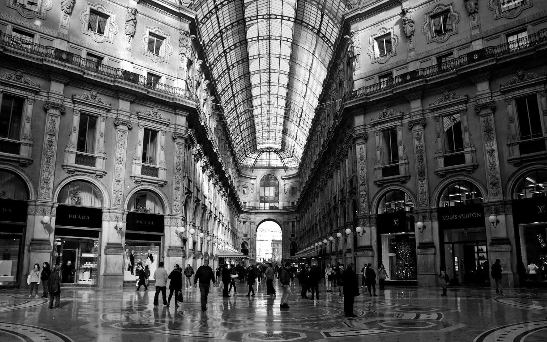 Black And White Architecture 桌布 壁紙 — 一張黑白照片，展示了一個宏偉華麗的購物拱廊，設有玻璃屋頂和豪華品牌商店。