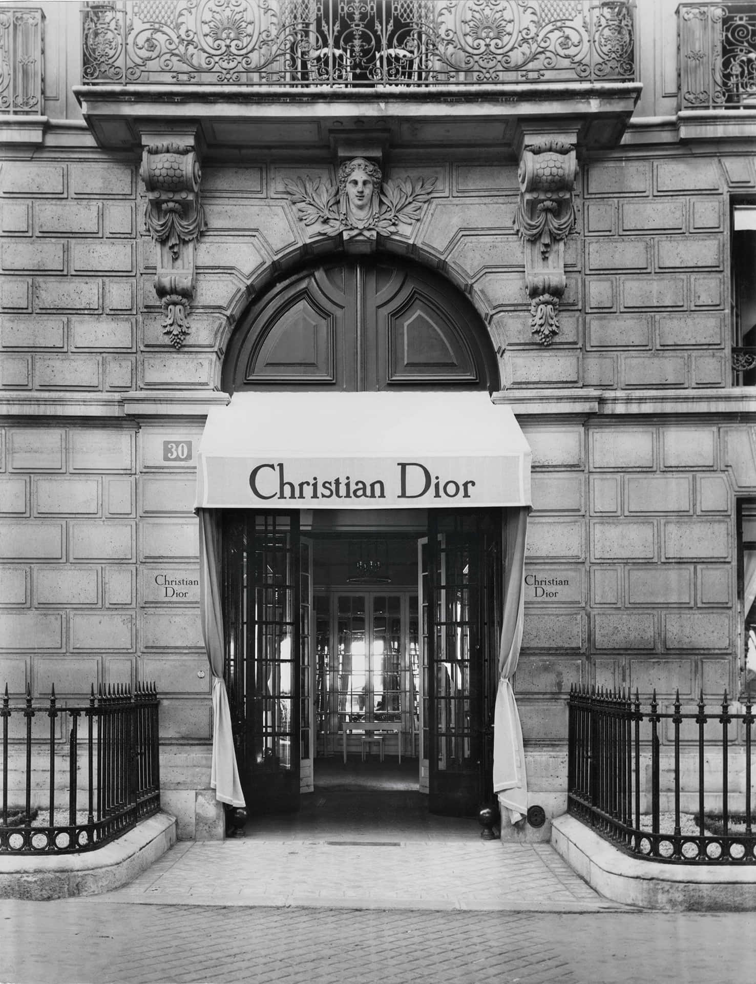 一張黑白照片，建築物上有 Christian Dior 的招牌 壁紙