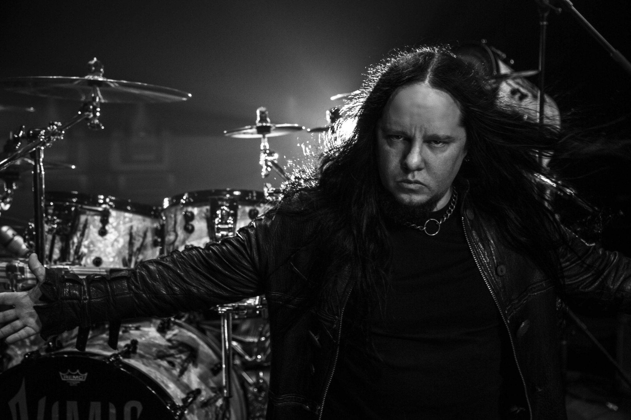 Joey Jordison 桌布 壁紙 — 一張黑白照片，拍攝一位長髮重金屬鼓手在舞台上表演，身後有鼓組。