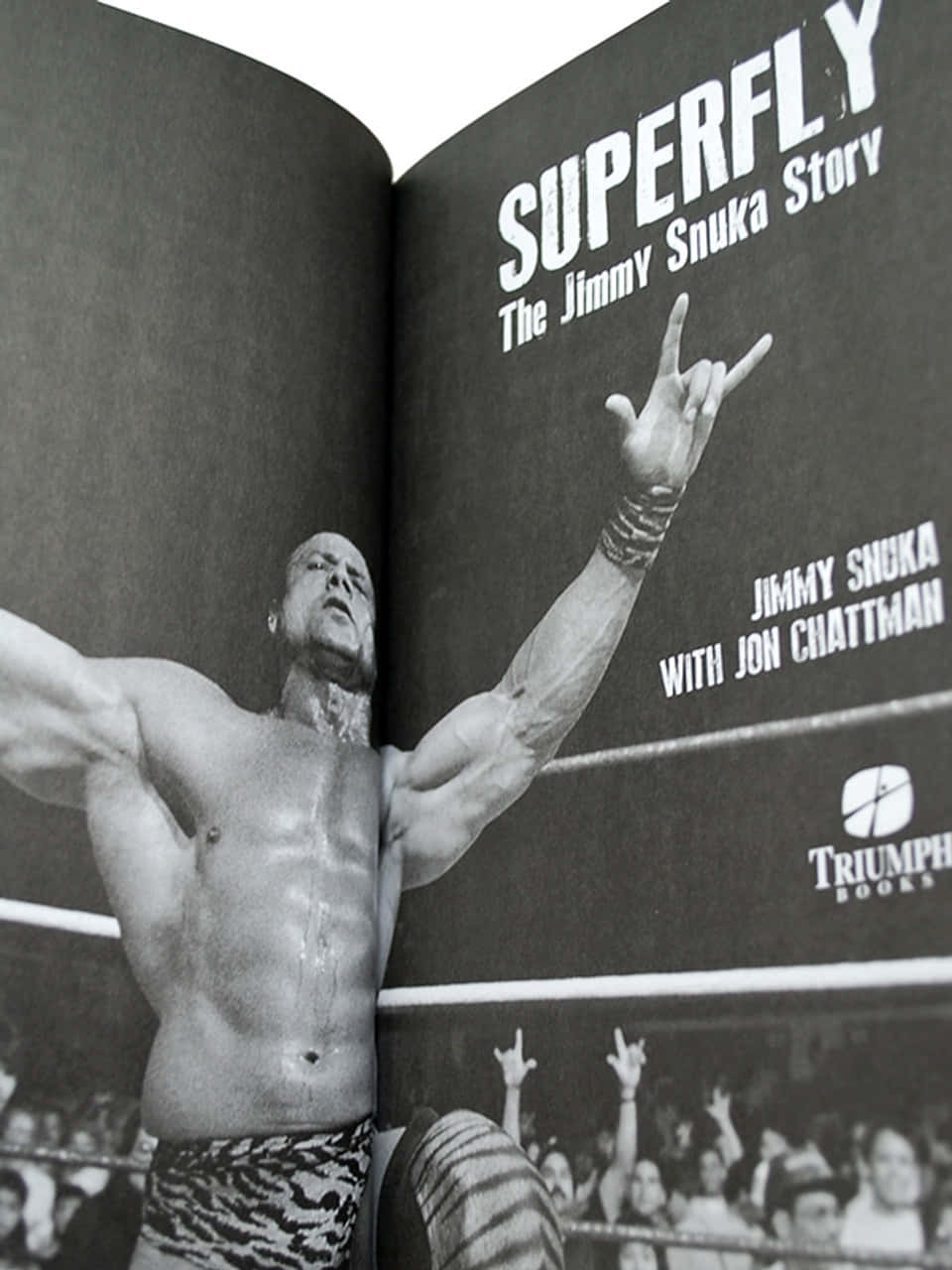 高清 桌布 壁紙 — 一張黑白照片，摔角手 Jimmy Snuka 在擂台上做出搖滾手勢，身後有粉絲歡呼。