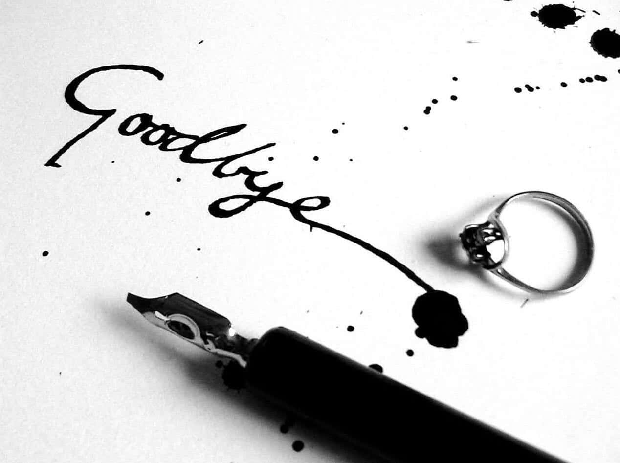 一張黑白照片，畫面中有一枚戒指與一支筆，上面寫著「再見」 壁紙