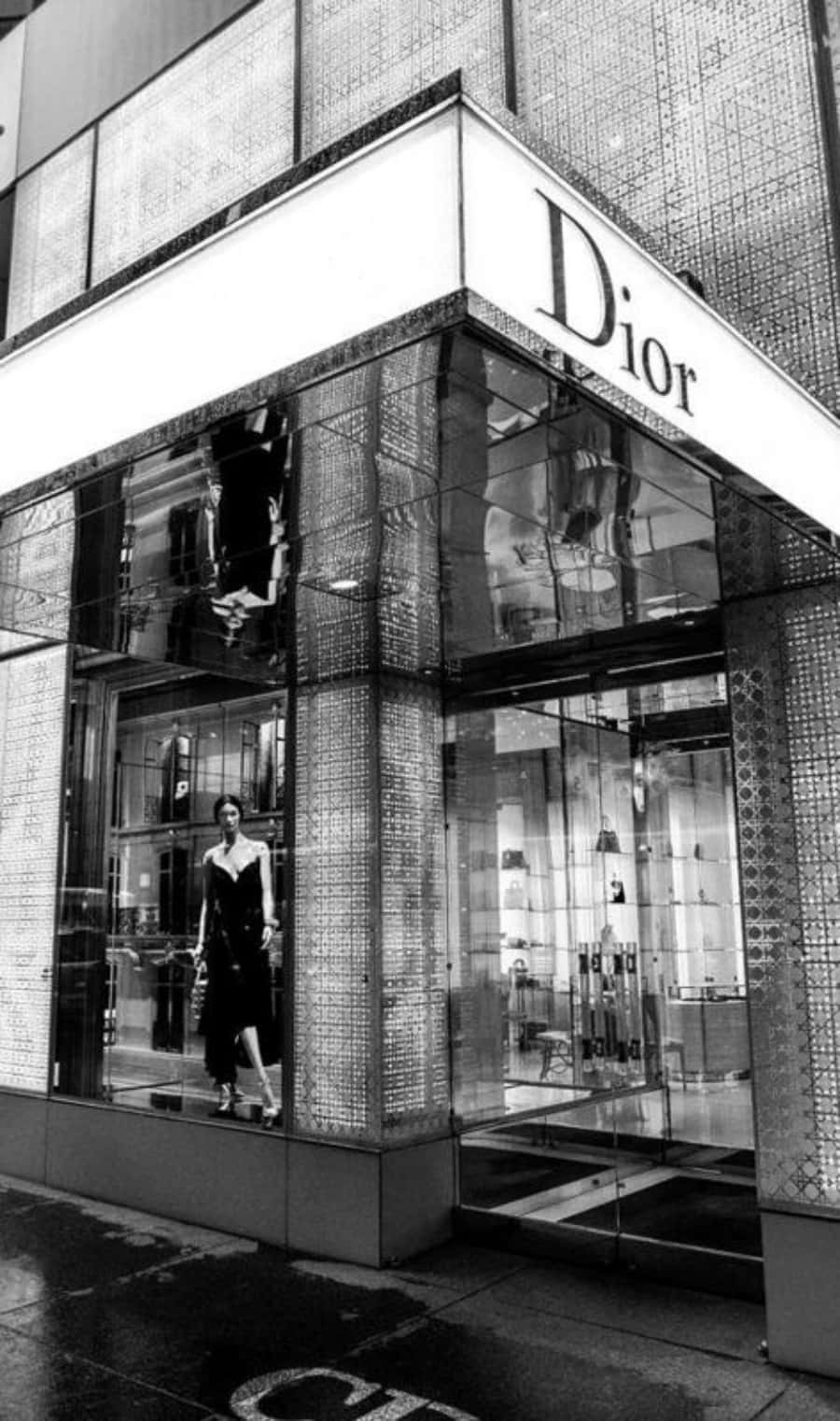 Dior 動態 桌布 壁紙 — 一張黑白照片，顯示Dior精品店角落，櫥窗內有模特兒，街道濕漉漉。
