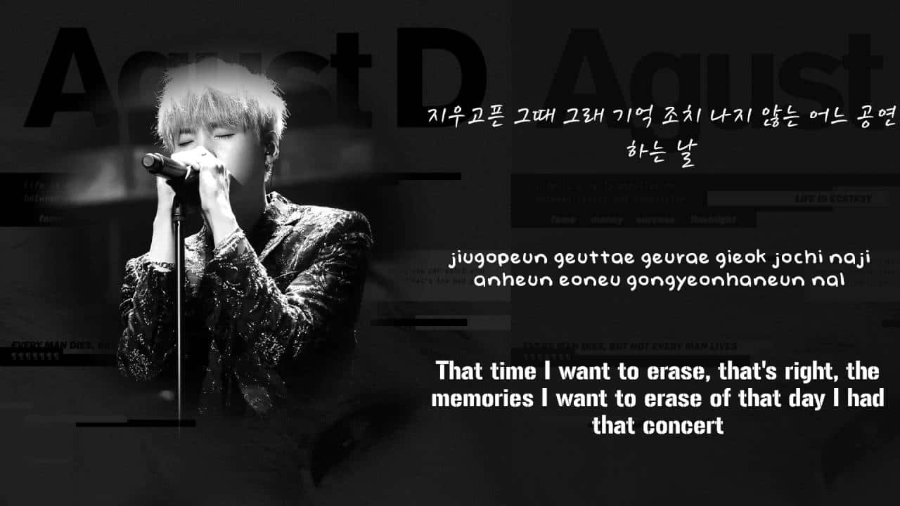 Agust D 桌布 壁紙 — 一張黑白照片，顯示一位男歌手熱情地對著麥克風演唱，並疊加了韓文和英文歌詞。