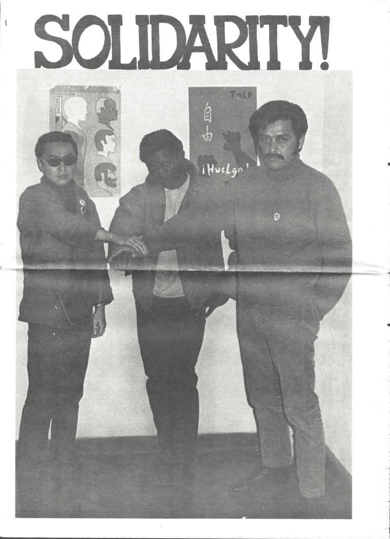 Black Panther Party 桌布 壁紙 — 一張黑白照片中，三名男子在粗體「SOLIDARITY!」橫幅下挽臂，背後有抗議海報。