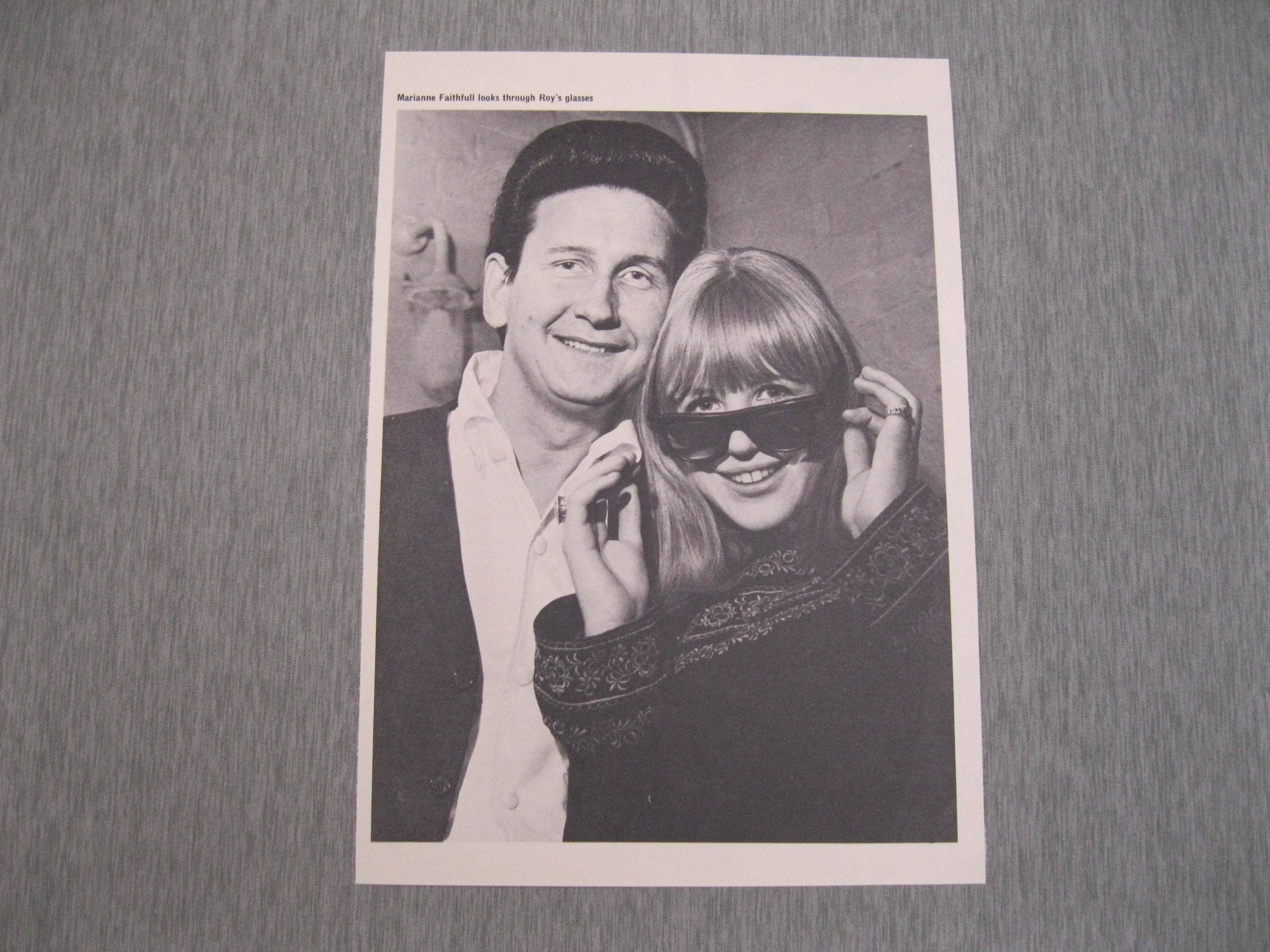 Retro 桌布 壁紙 — 一張黑白照片印刷顯示 Marianne Faithfull 透過 Roy 的眼鏡微笑，同時拿著眼鏡，兩人都看著相機。