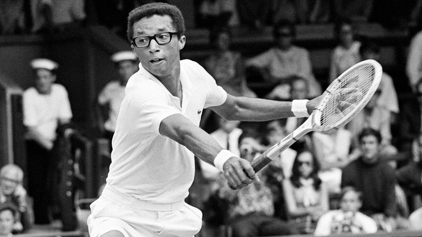 Tennis 桌布 壁紙 — 一張黑白照片捕捉到一位專注的網球選手正在揮拍，背景中的觀眾模糊不清。