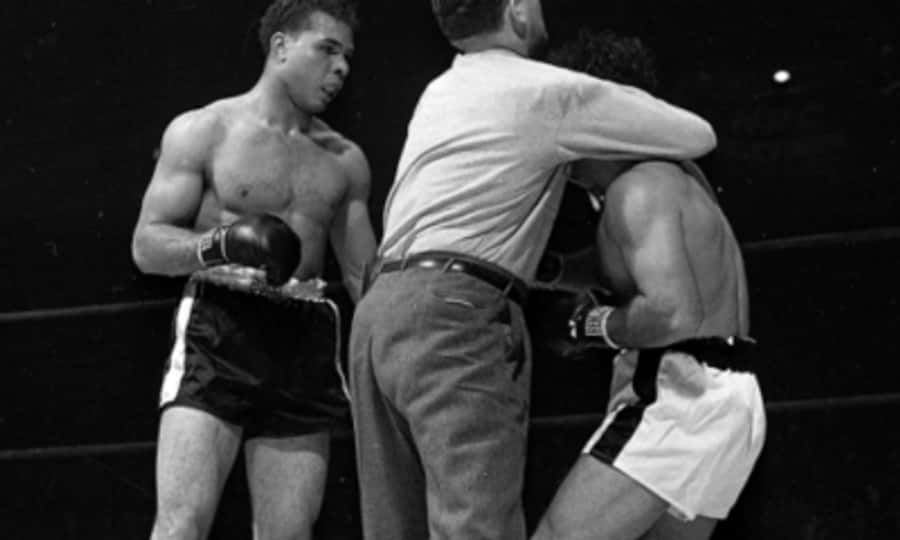 Boxing 桌布 壁紙 — 一張黑白照片捕捉到一名拳擊手警覺地站立，而裁判在擂台上將他與對手分開。