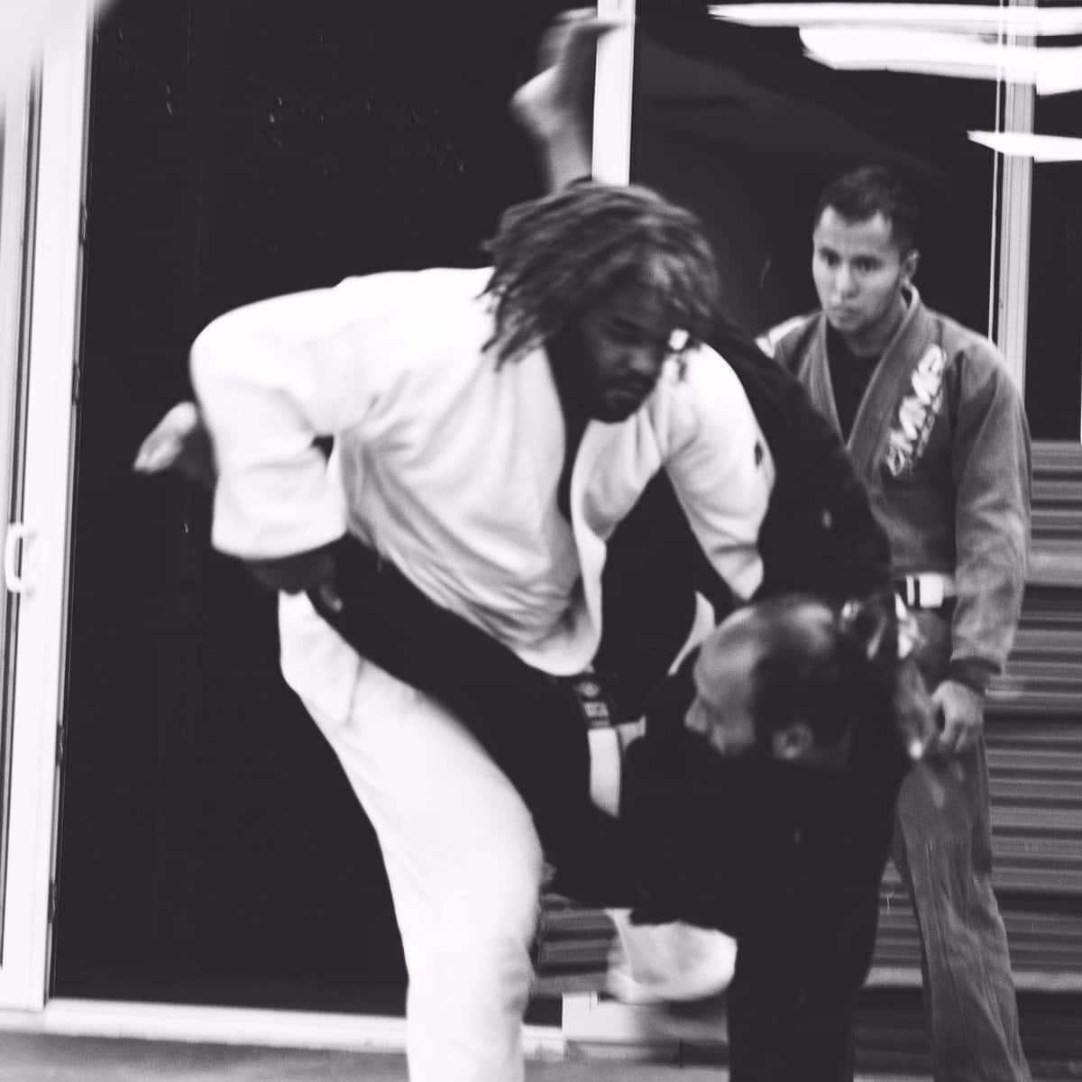 martial arts 桌布 壁紙 — 一張黑白照片捕捉到動態武術投摔，動態模糊強調速度與強度。