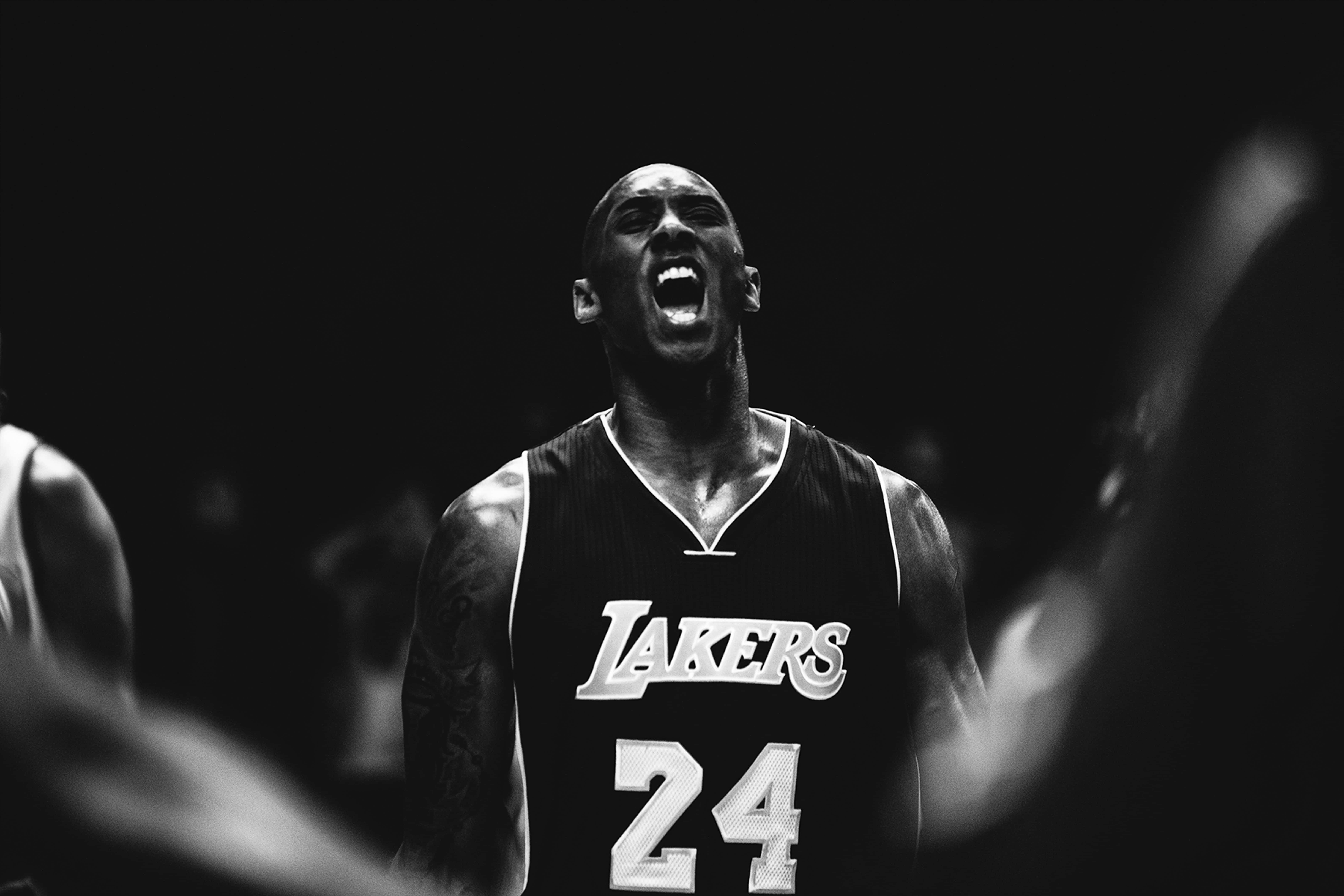 NBA 桌布 壁紙 — 一張黑白照片捕捉到柯比布萊恩穿著湖人球衣在籃球比賽中激情吶喊。