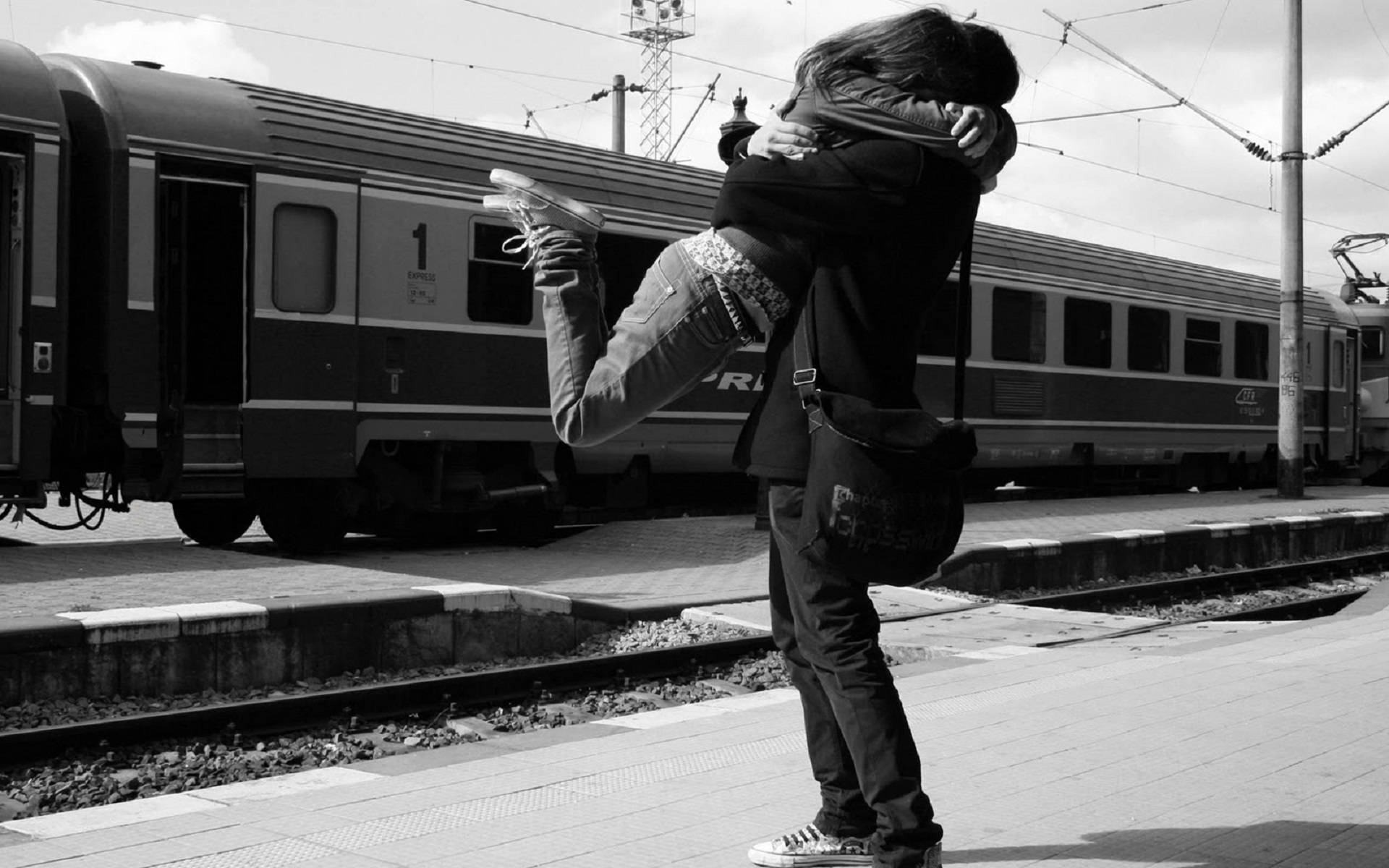 Romantic Love 桌布 壁紙 — 一張黑白照片捕捉到火車站月台上兩人之間喜悅的擁抱，而火車就在附近等待。