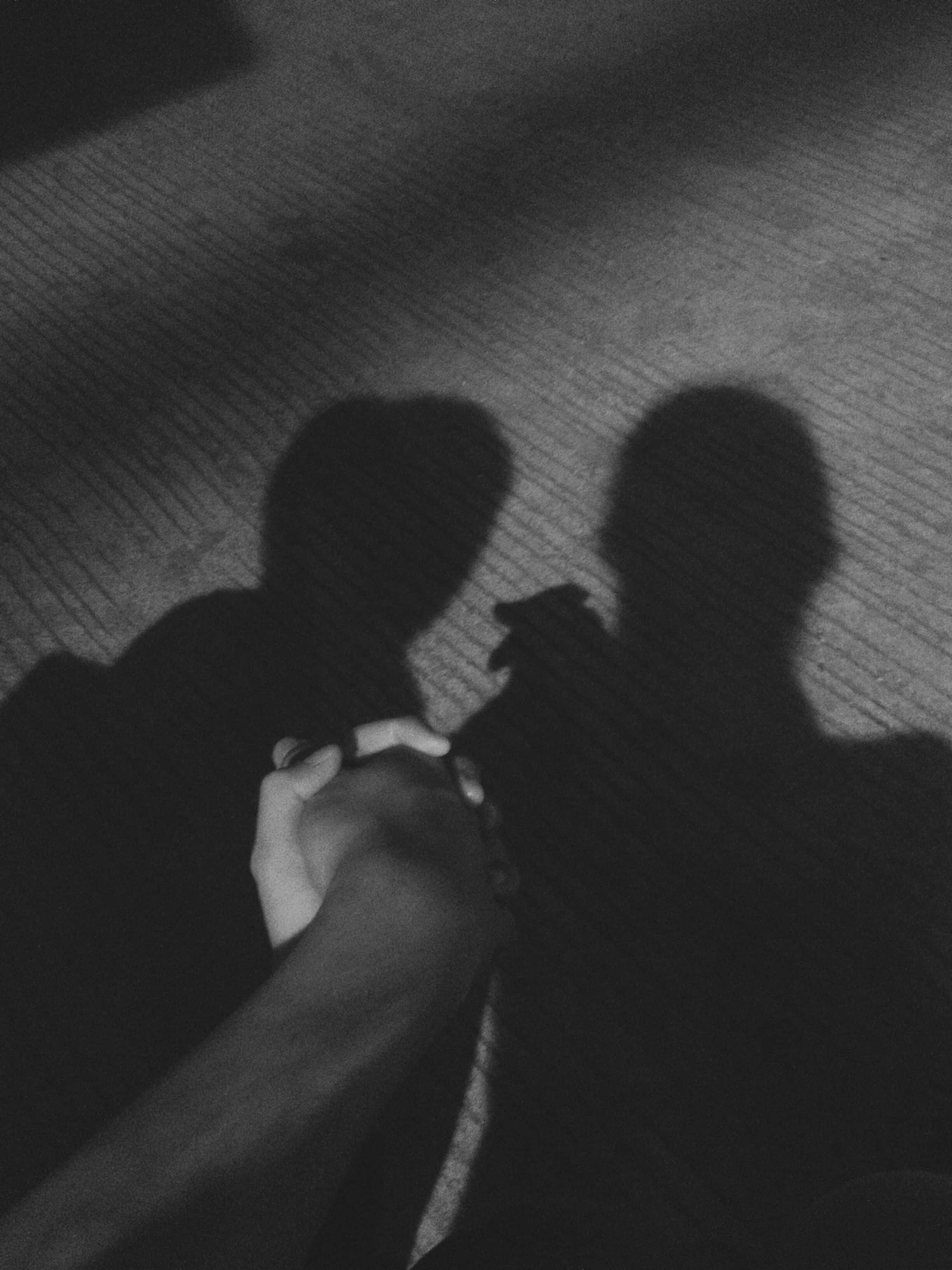 Relationship 桌布 壁紙 — 一張黑白照片顯示兩個剪影人物在紋理地毯上牽手，光線效果戲劇化。