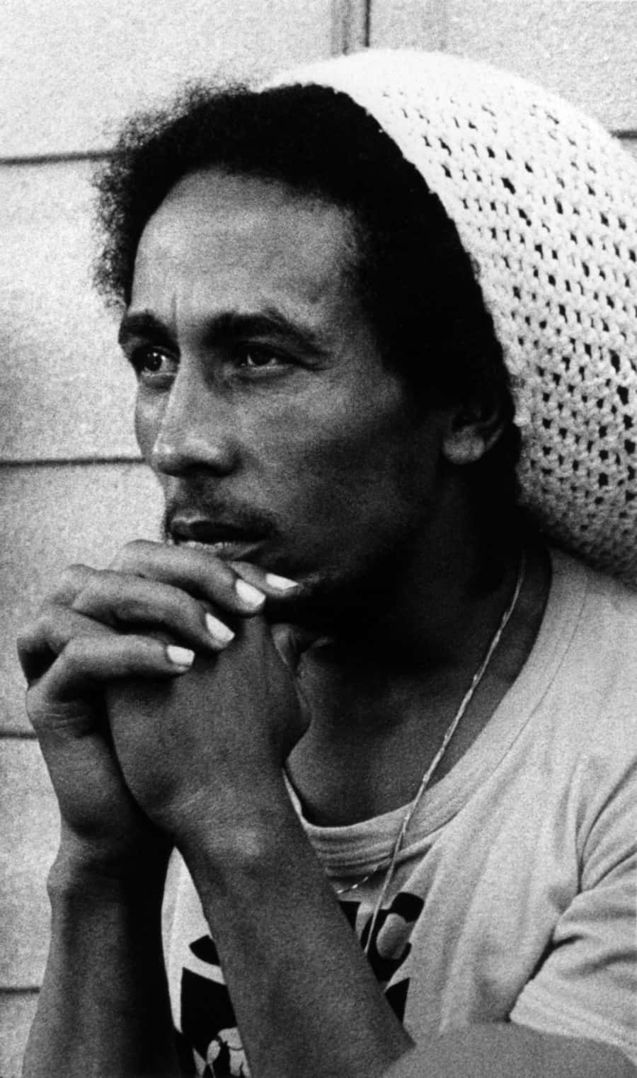 Bob Marley 桌布 壁紙 — 一張黑白肖像，Bob Marley戴著鉤針編織帽，手持香煙，神情沉思。