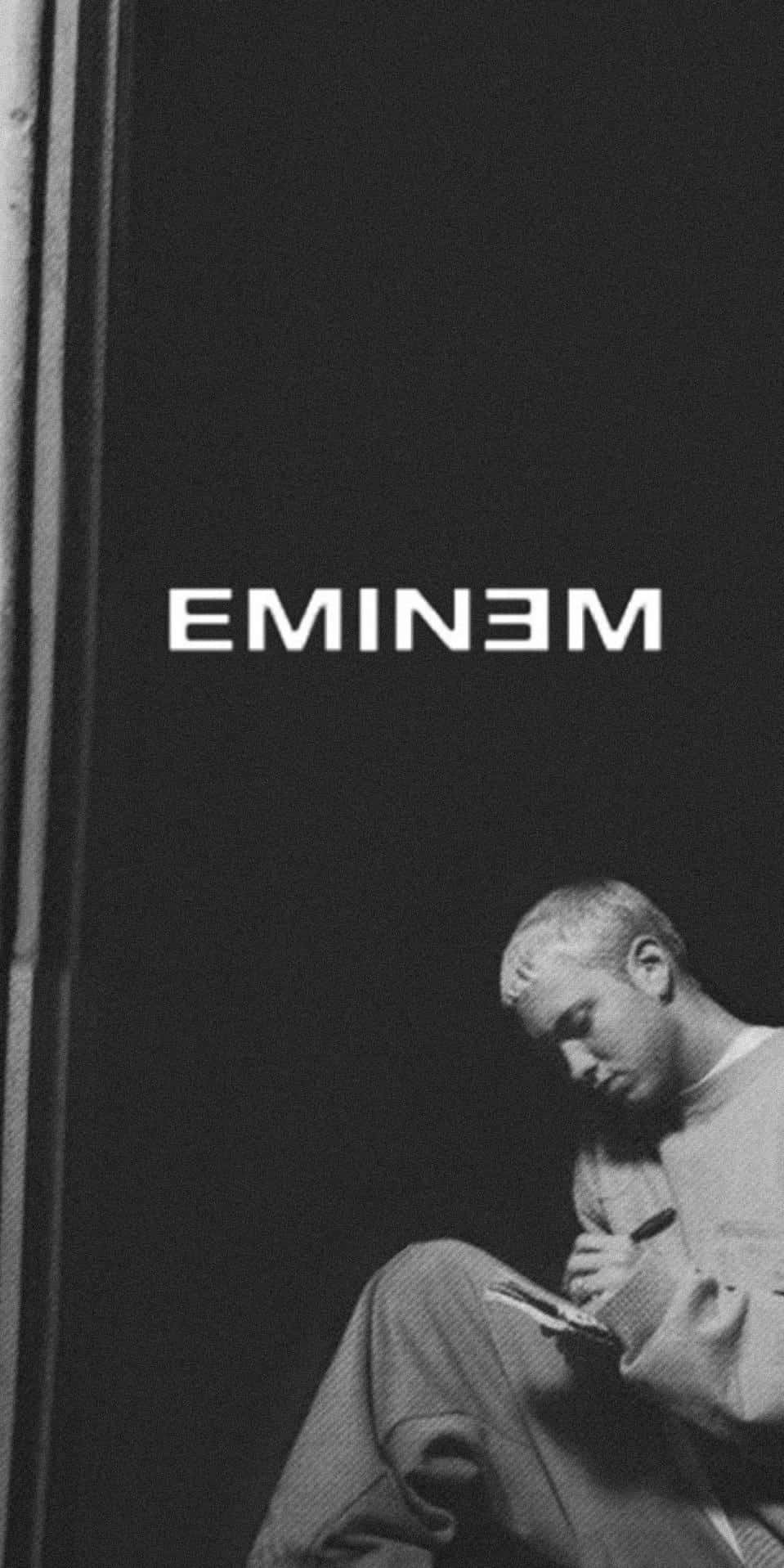 阿姆 桌布 壁紙 — 一張黑白肖像，Eminem 沉思地坐著，在黑暗背景下寫筆記本。
