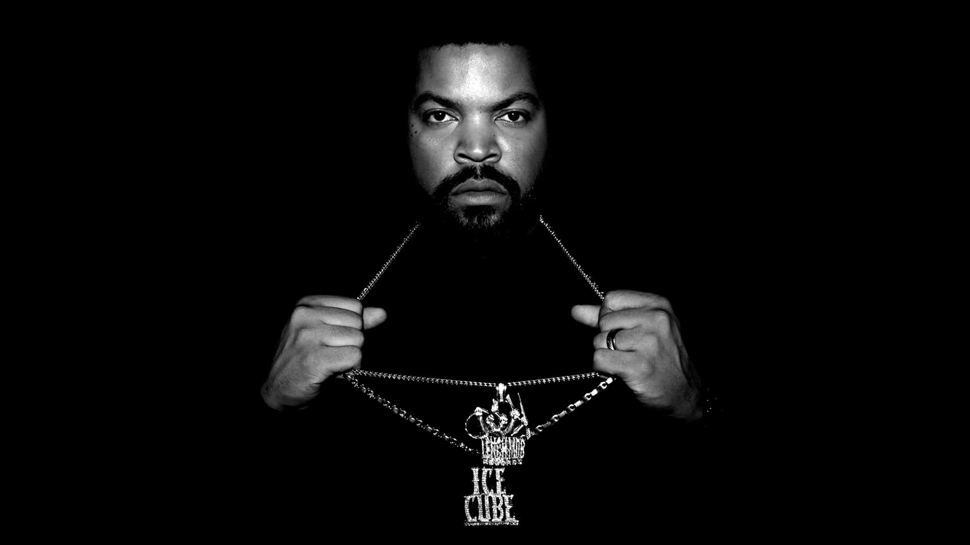 Celebrity 桌布 壁紙 — 一張黑白肖像，Ice Cube 在深色背景前舉起一條帶有他名字吊墜的鏈條。