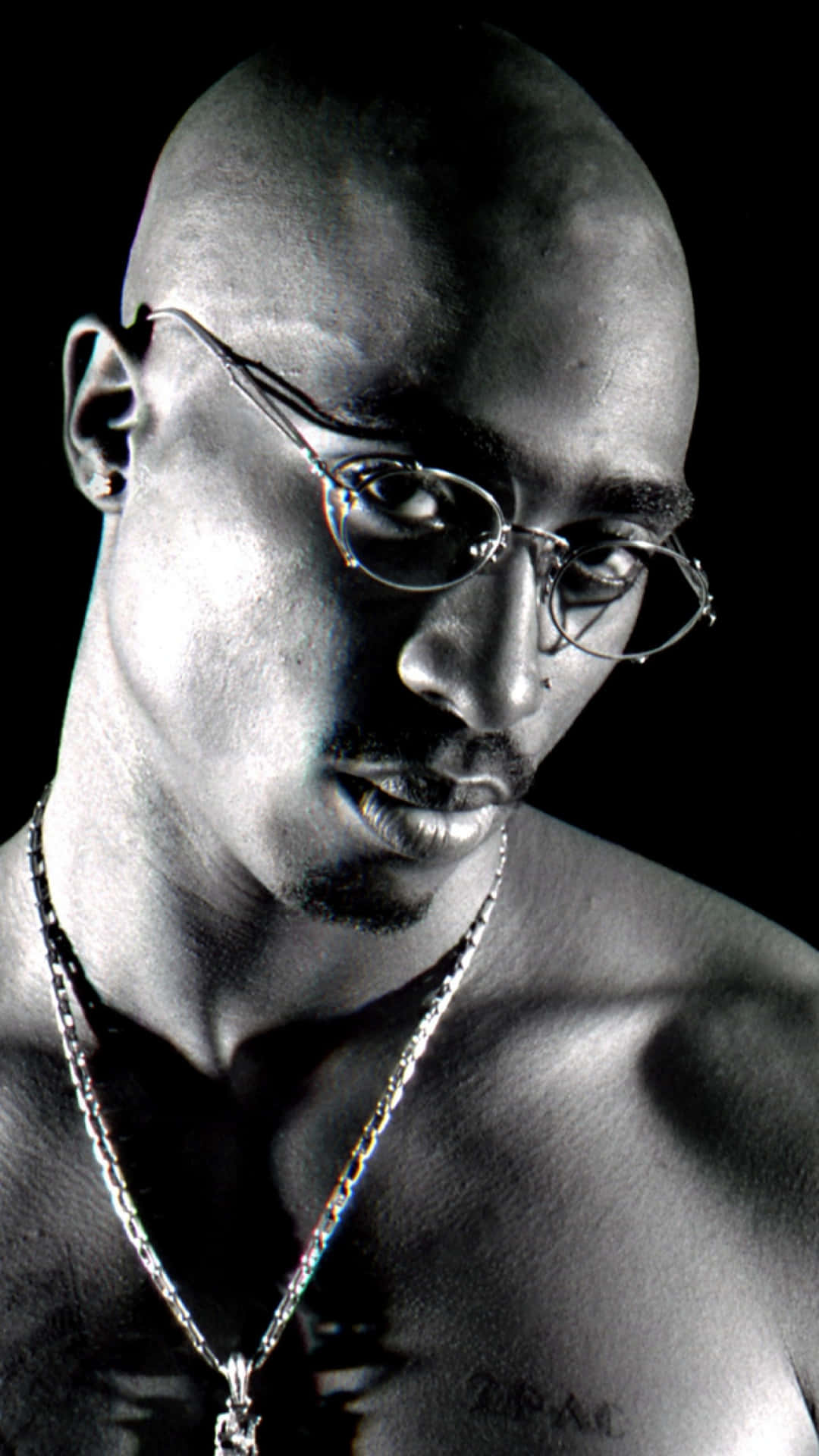 tupac 桌布 壁紙 — 一張黑白肖像，Tupac Shakur 戴著眼鏡和鏈條，背景深色。