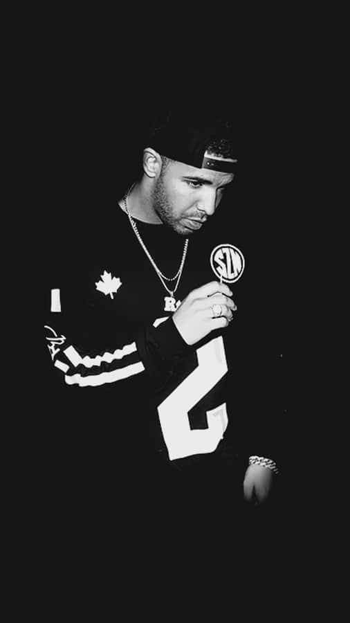 Aesthetic Drake 桌布 壁紙 — 一張黑白肖像，一名戴帽子和球衣的男子在黑暗背景前手持圓形物體。