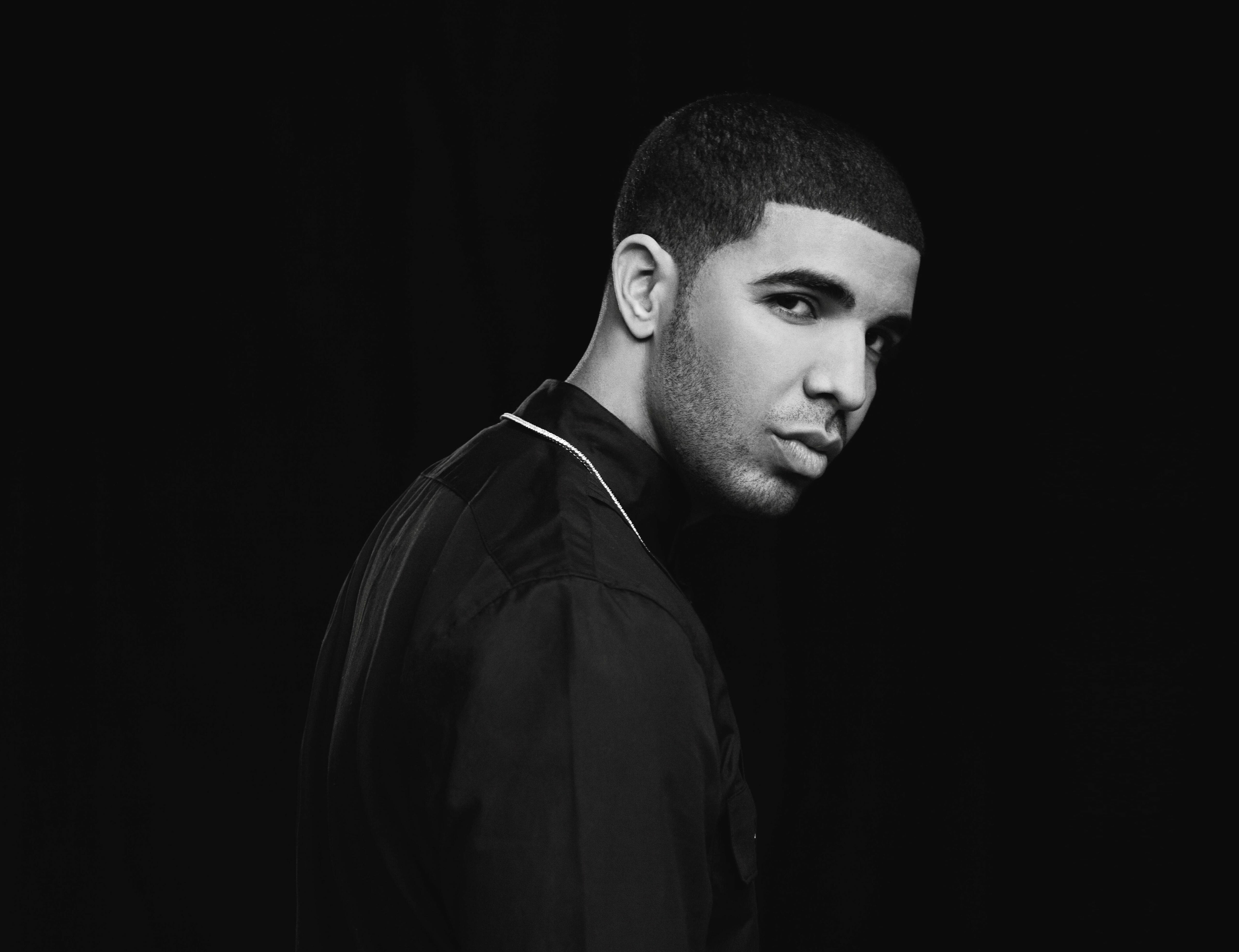 Drake 桌布 壁紙 — 一張黑白肖像，側面男子，背景黑暗，燈光戲劇性。