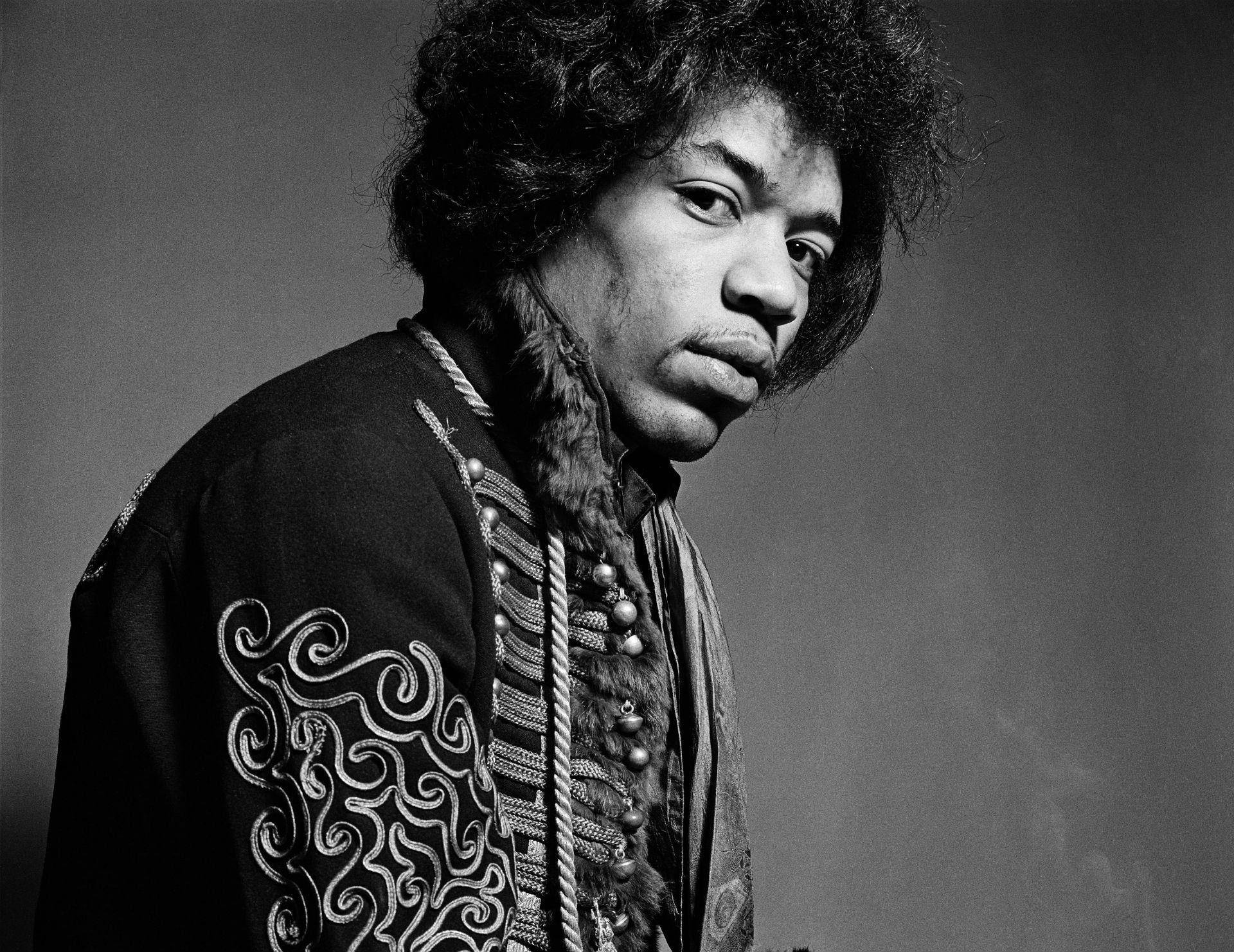 黑白 桌布 壁紙 — 一張黑白肖像，吉米·亨德里克斯（Jimi Hendrix）捲髮、穿著華麗外套，專注地凝視鏡頭。