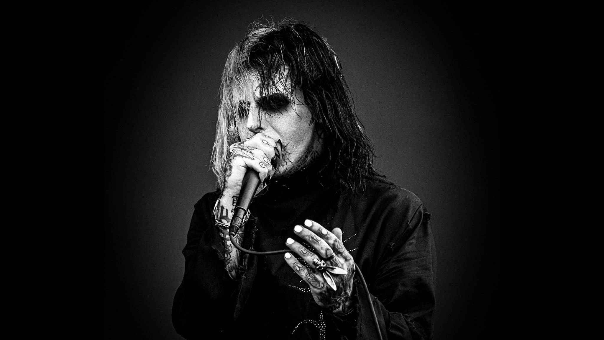 Ghostemane 桌布 壁紙 — 一張黑白肖像，描繪一位刺青音樂家，化著深色妝容，在漸層背景前對著麥克風唱歌。