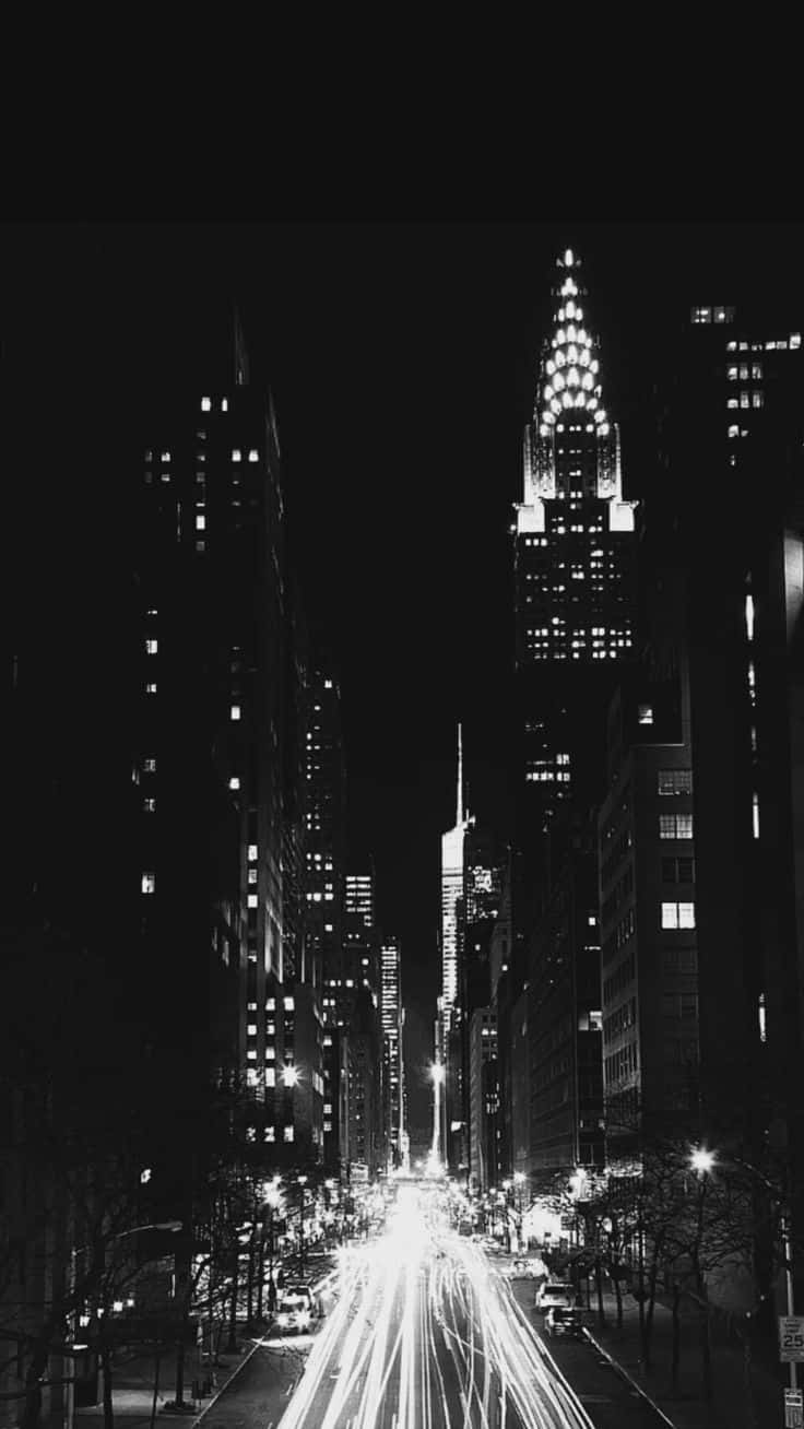 Black And White Street 桌布 壁紙 — 一張黑白長曝光照片，拍攝紐約市繁華街道的夜景，車燈形成流動光軌，標誌性的克萊斯勒大廈高聳入雲。