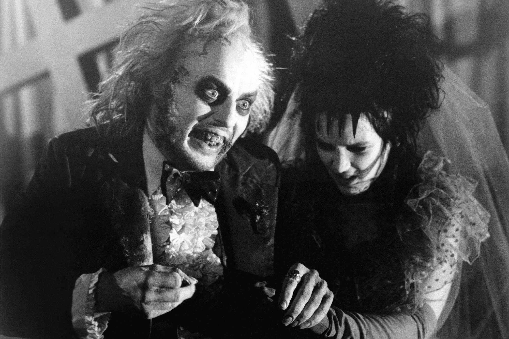 Beetlejuice 桌布 壁紙 — 一張黑白電影劇照顯示Beetlejuice和一位哥德妝容的新娘緊握雙手，表情強烈。