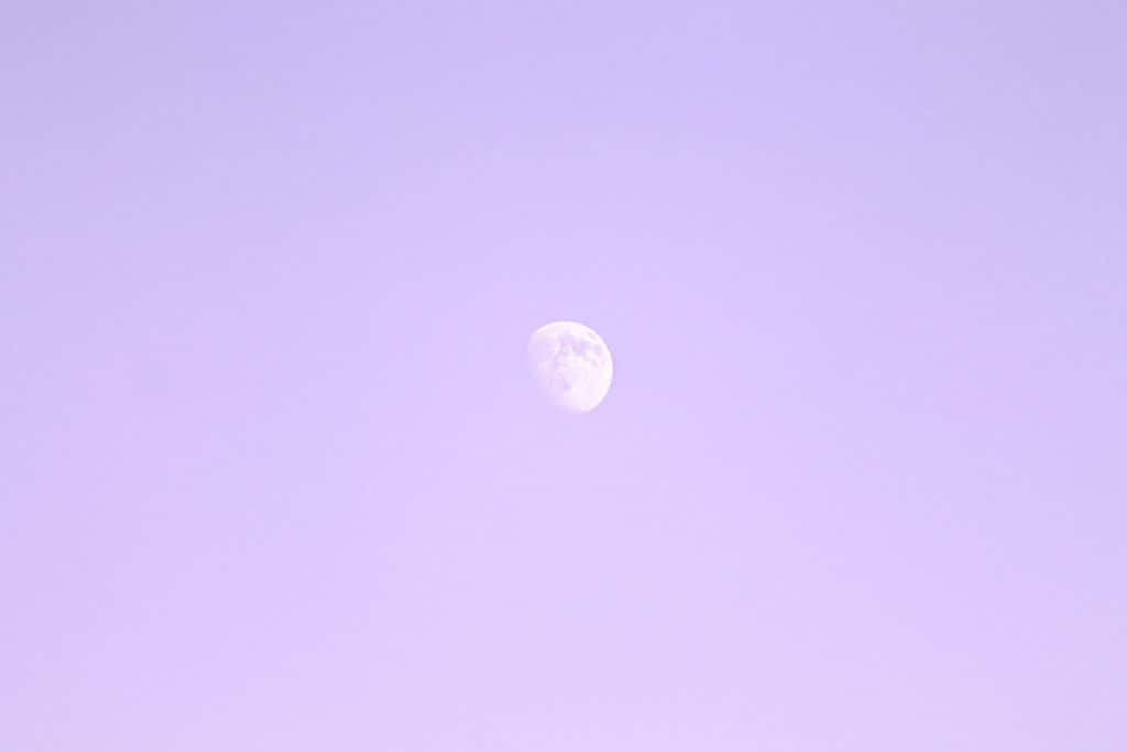 Pastel Minimalist 桌布 壁紙 — 一彎寧靜的弦月在夢幻的薰衣草色暮光天空中柔和地發光。