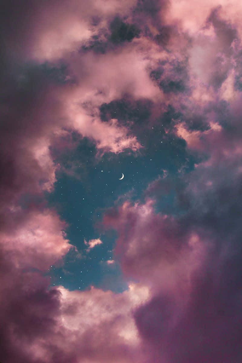 Dream Aesthetic 桌布 壁紙 — 一彎新月和星星在夢幻般的夜空中，從旋轉的粉紅色和紫色雲層中探出頭來。