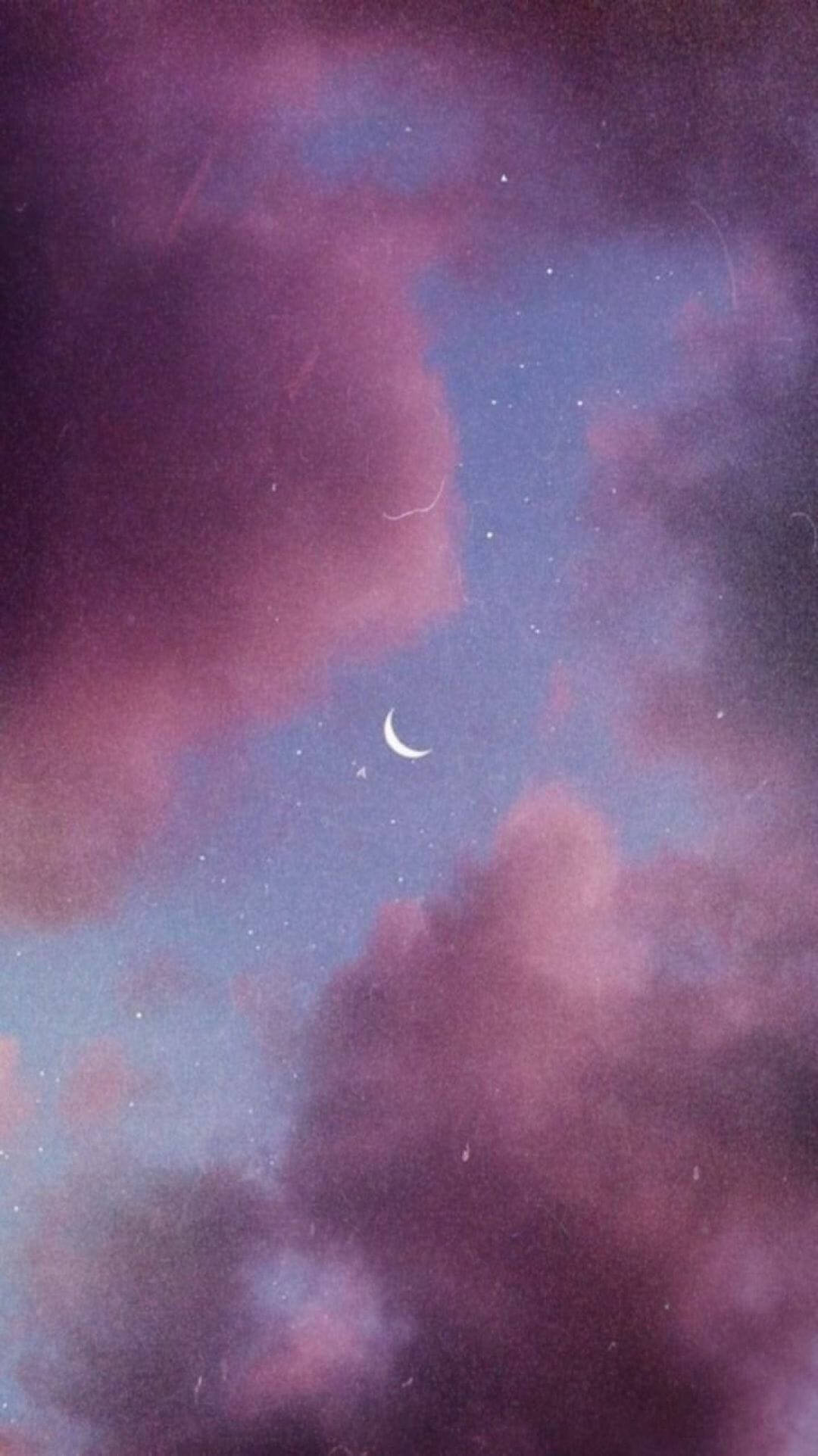 月光 桌布 壁紙 — 一彎新月在夢幻般的紫色雲層間柔和發光，下方是星光閃爍的暮色天空。