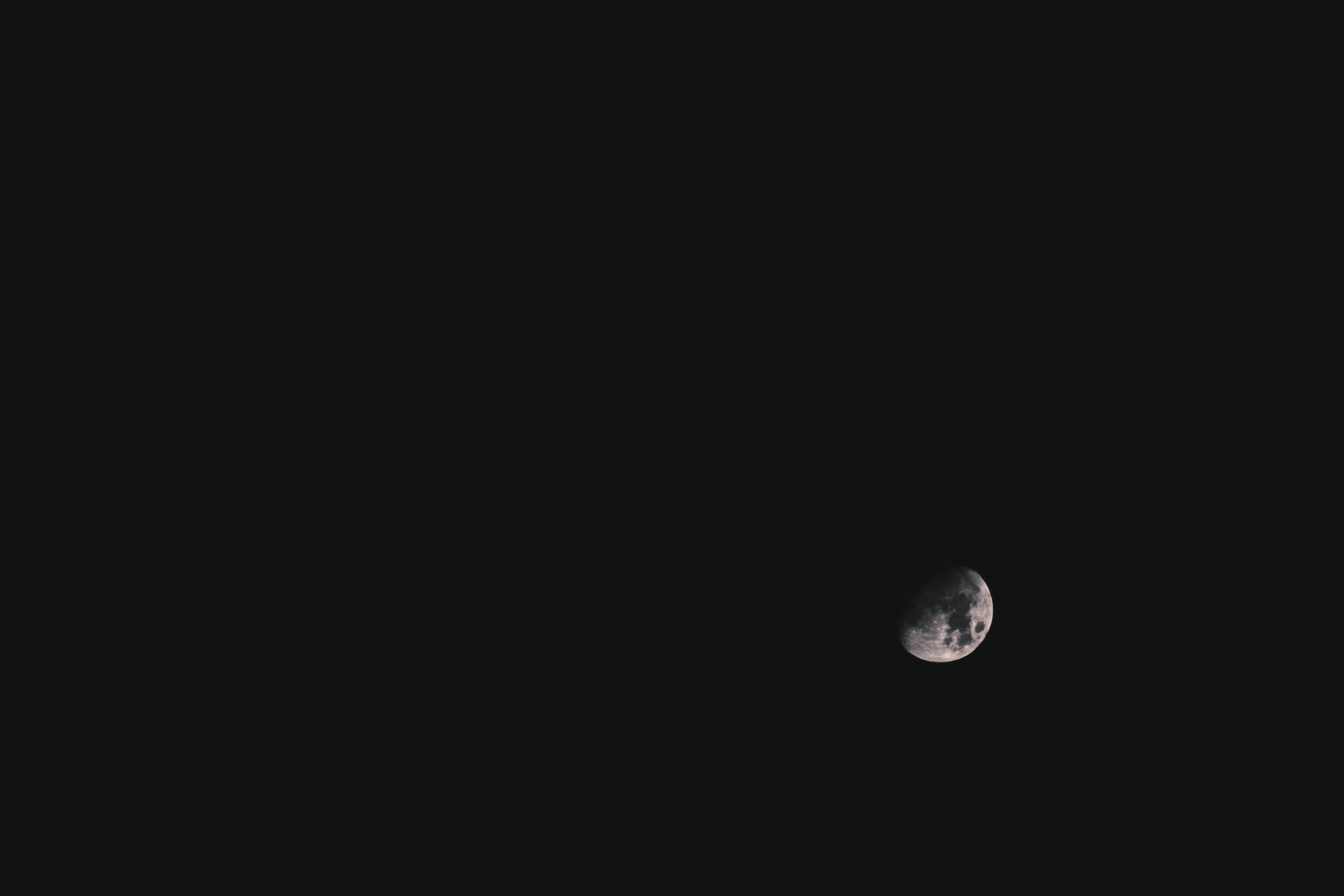 月亮桌面 桌布 壁紙 — 一彎新月在廣闊漆黑的夜空中柔和地發光。