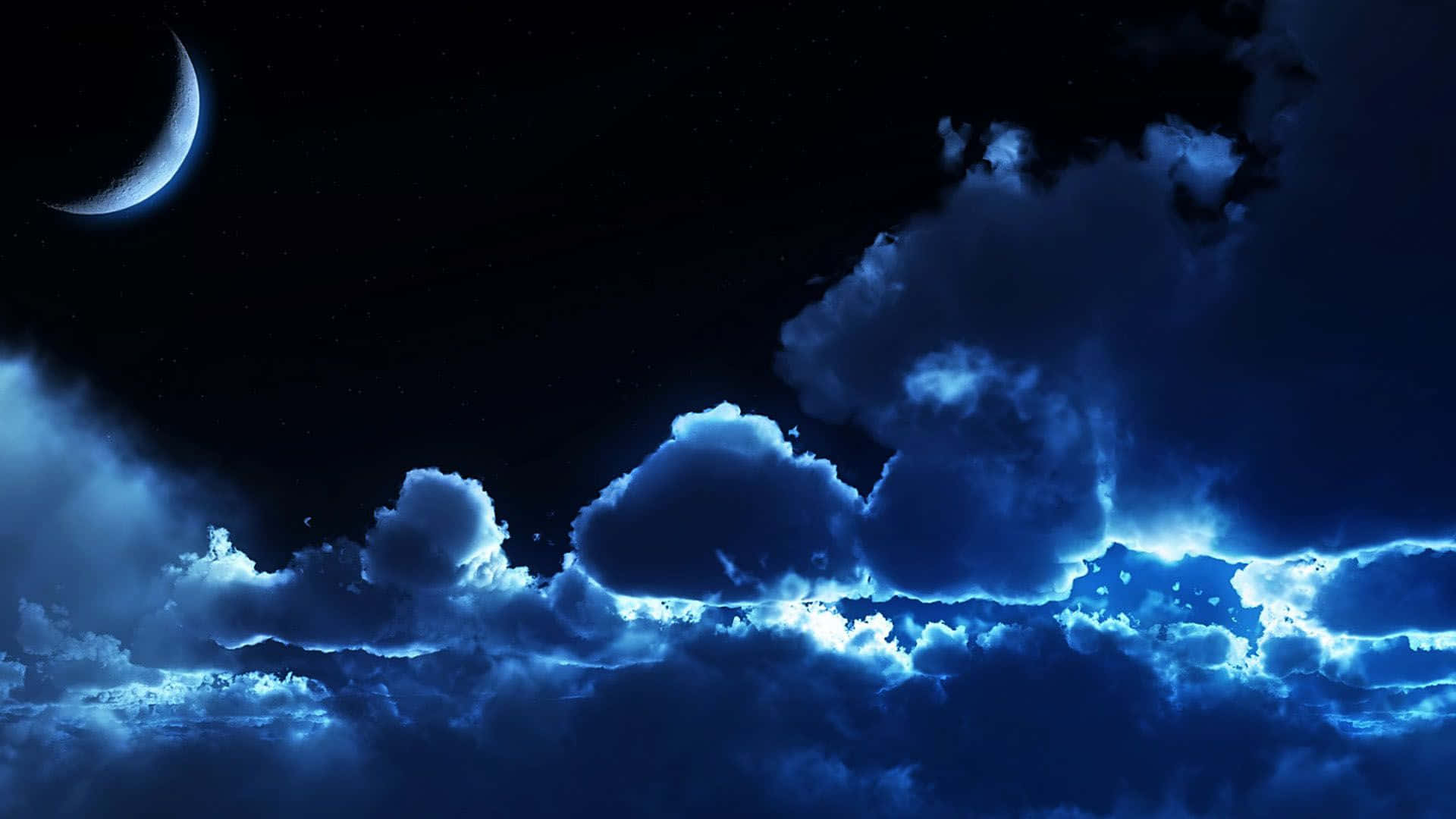 雲朵 桌布 壁紙 — 一彎新月在戲劇性的藍色雲層上方發光，雲層被空靈的光芒照亮，背景是繁星點點的夜空。