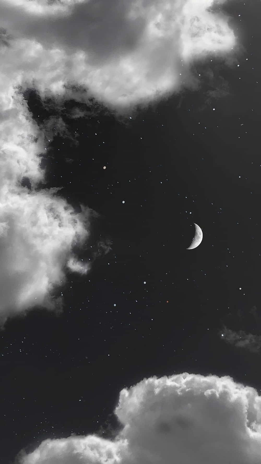 黑白 桌布 壁紙 — 一彎新月在星星和飄動的雲朵中柔和發光，呈現單色夜空。