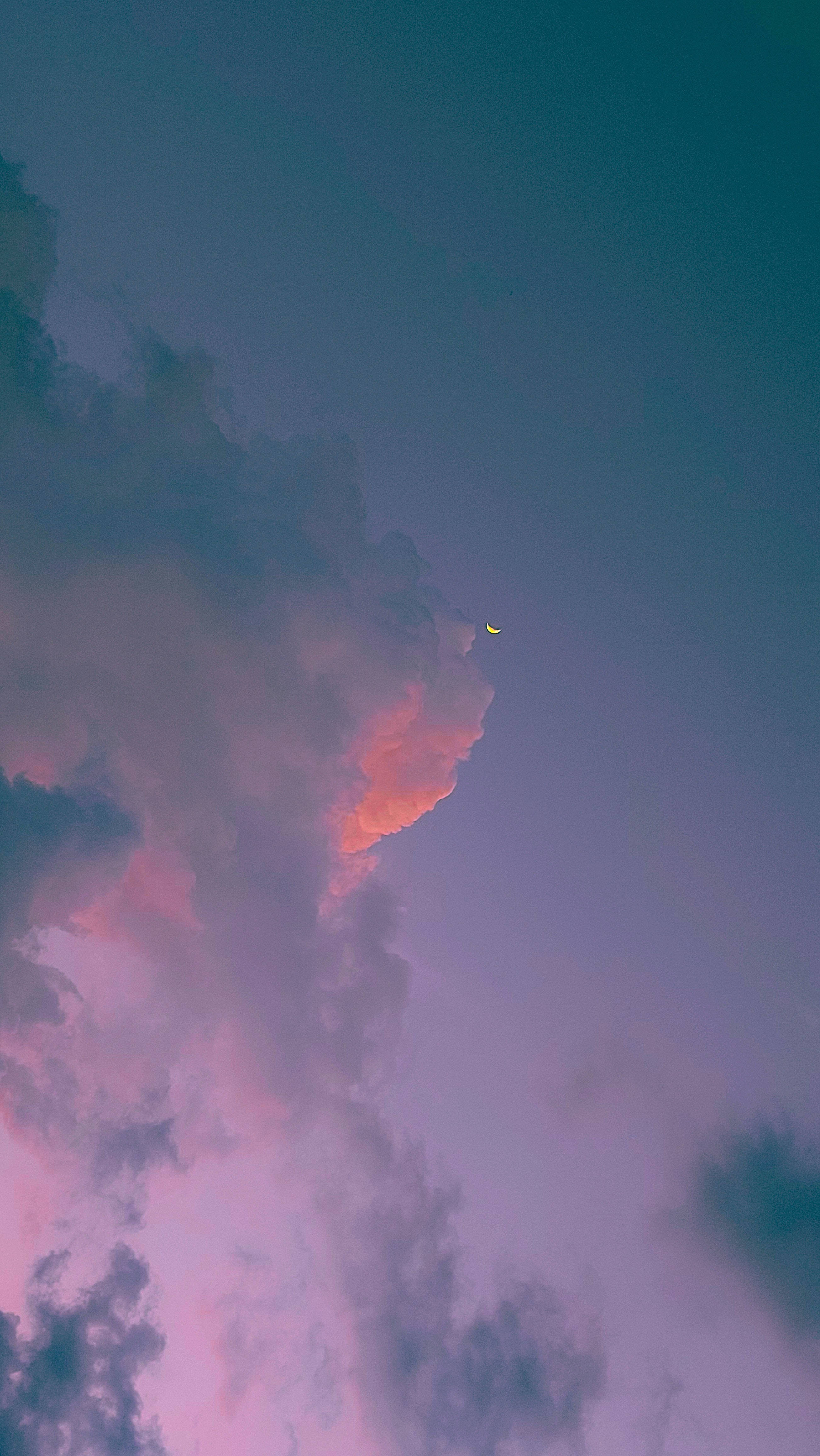 雲朵 桌布 壁紙 — 一彎新月在暮色天空中穿過柔和的粉紅色和紫色雲層窺視。