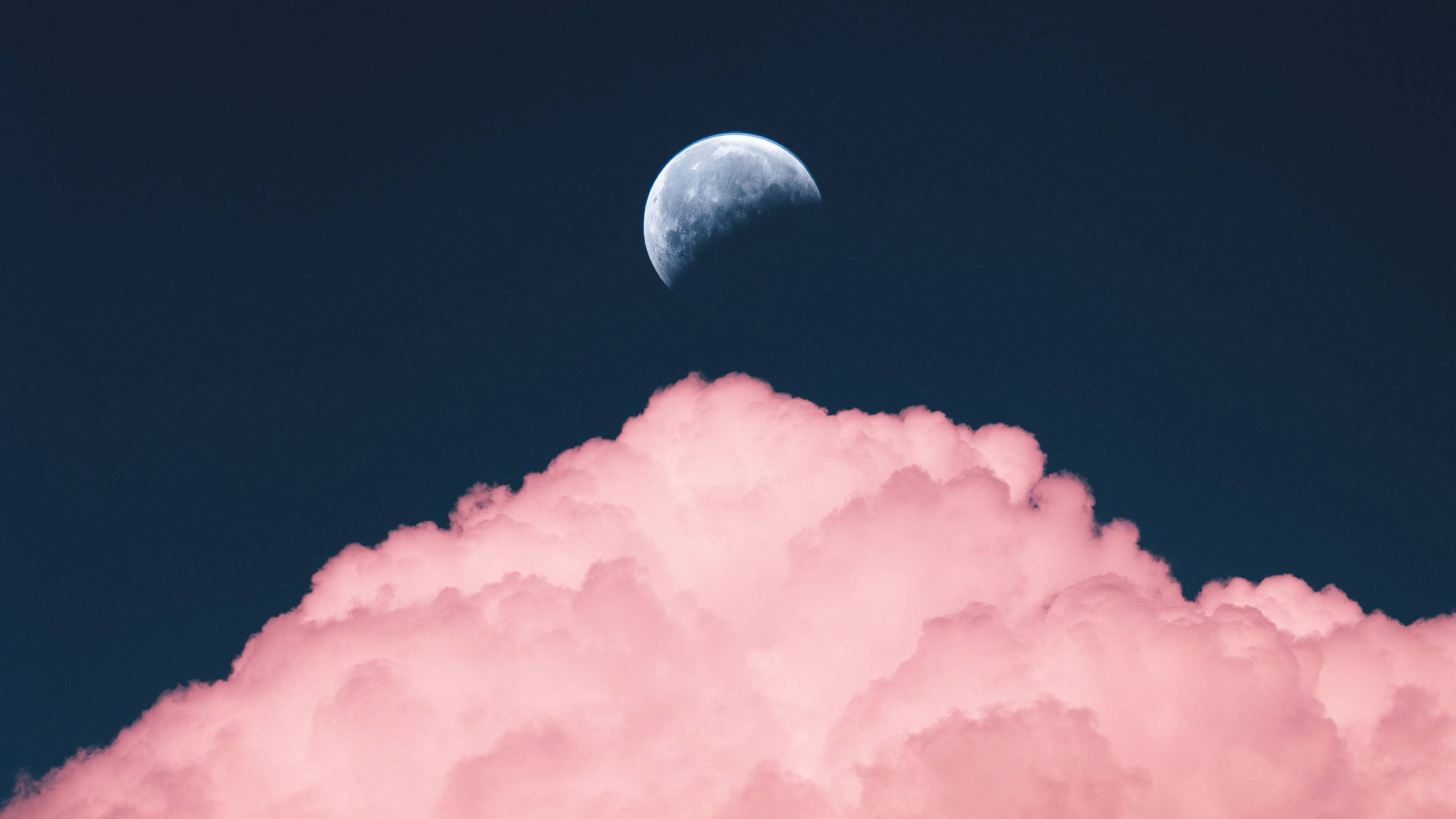 雲朵 桌布 壁紙 — 一彎新月在深藍色夜空中的柔軟粉紅雲朵上方發光。