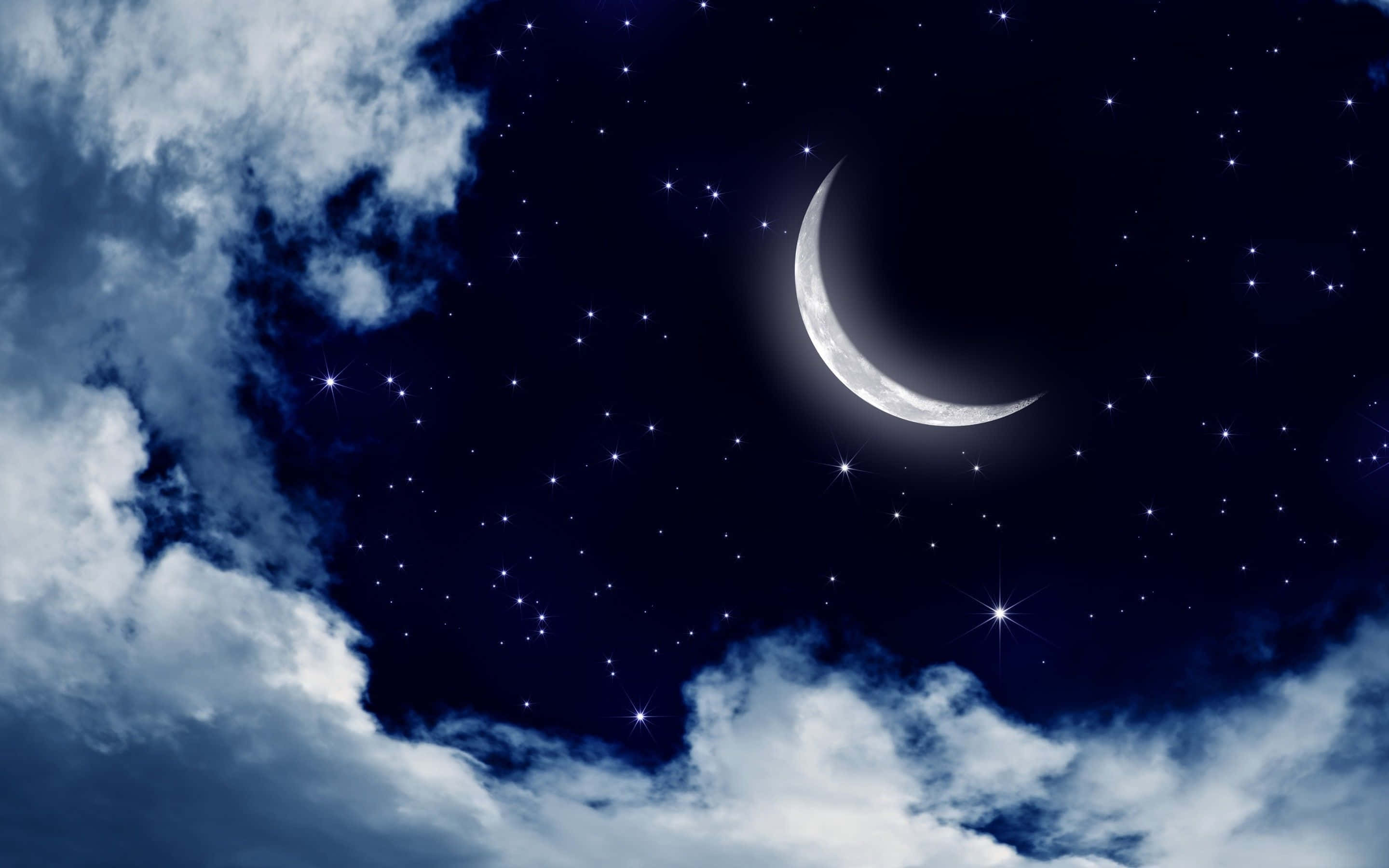 月亮與星星 桌布 壁紙 — 一彎新月在深藍色夜空中的閃爍星星和縷縷雲彩之間柔和地發光。
