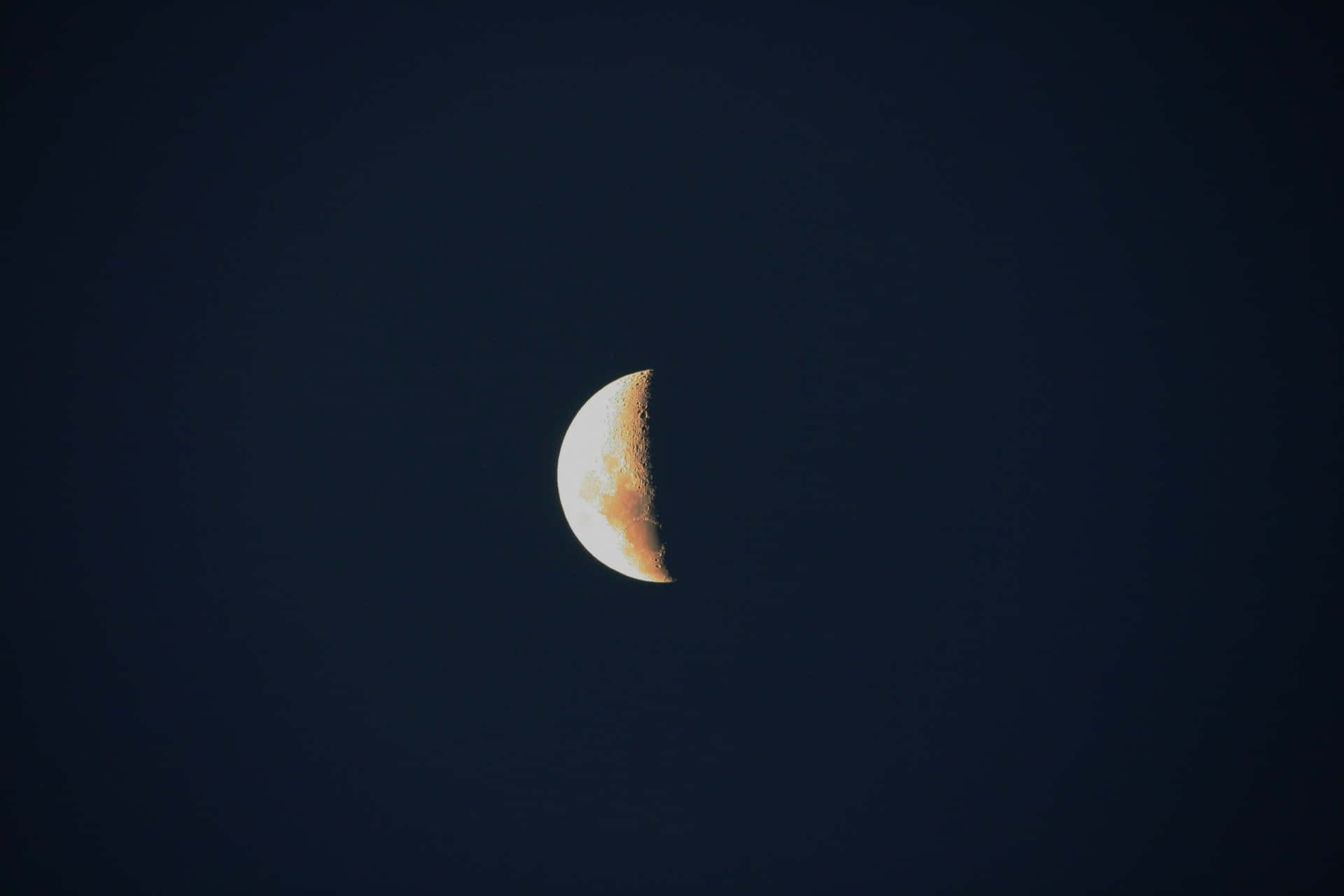 Half Moon 桌布 壁紙 — 一彎新月在深靛藍色的夜空中柔和地發光，表面細節清晰可見。