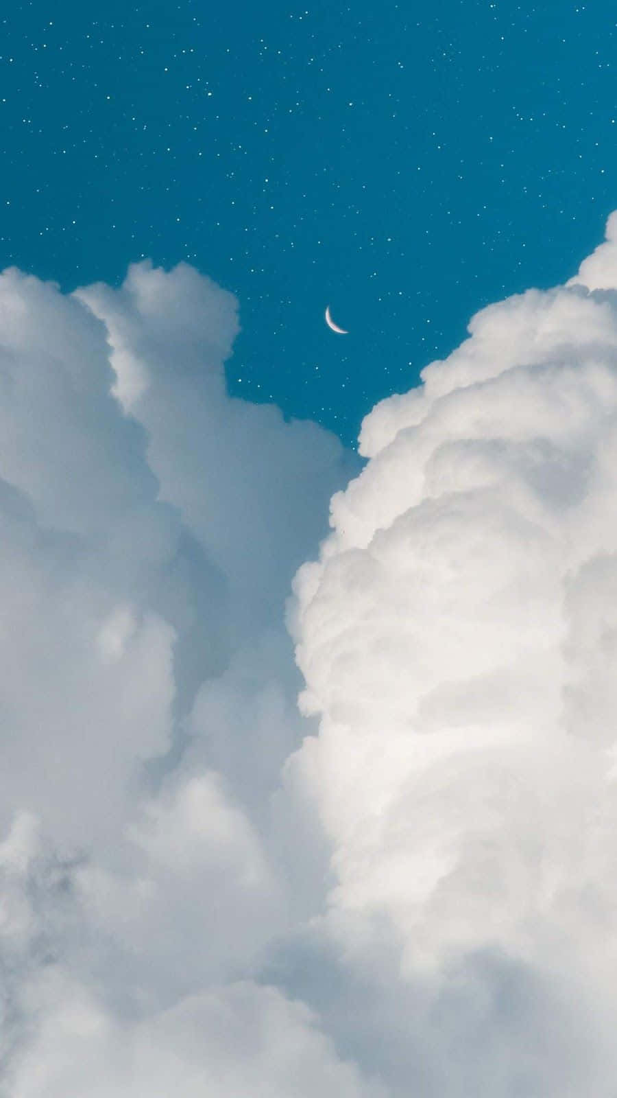 Blue Sky Aesthetic 桌布 壁紙 — 一彎新月在蓬鬆的白雲之間發光，在繁星點點的深藍色夜空下。