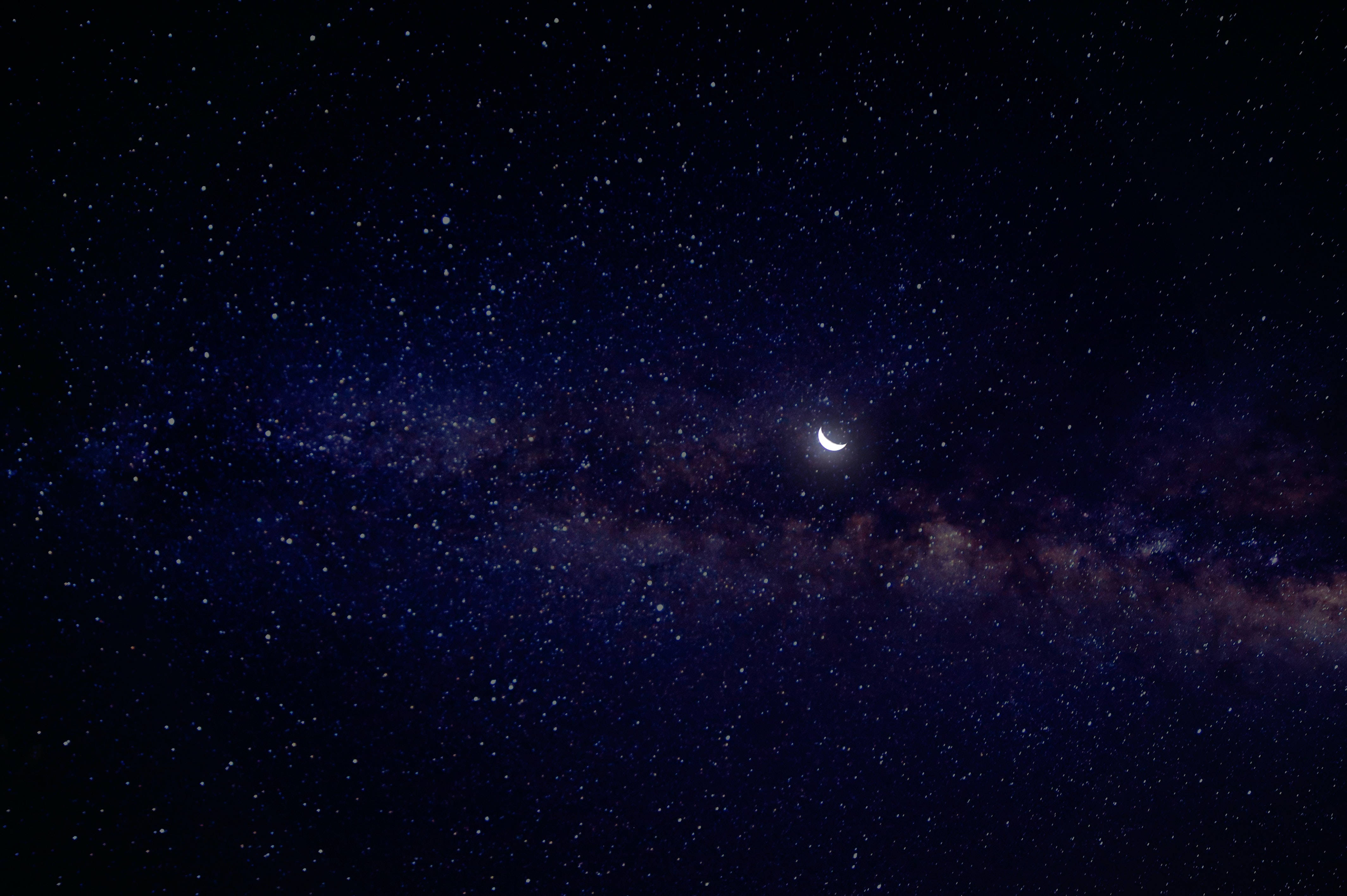 Crescent 桌布 壁紙 — 一彎新月在銀河發光帶上方柔和發光，映襯著深邃的星空夜空。