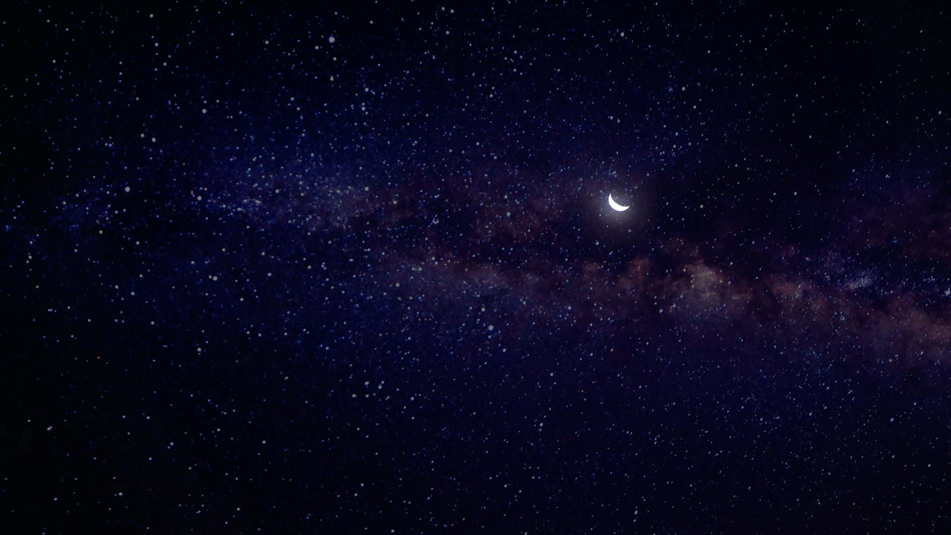 月亮與星星 桌布 壁紙 — 一彎新月在銀河發光帶上方閃耀，映襯著繁星點點的夜空。